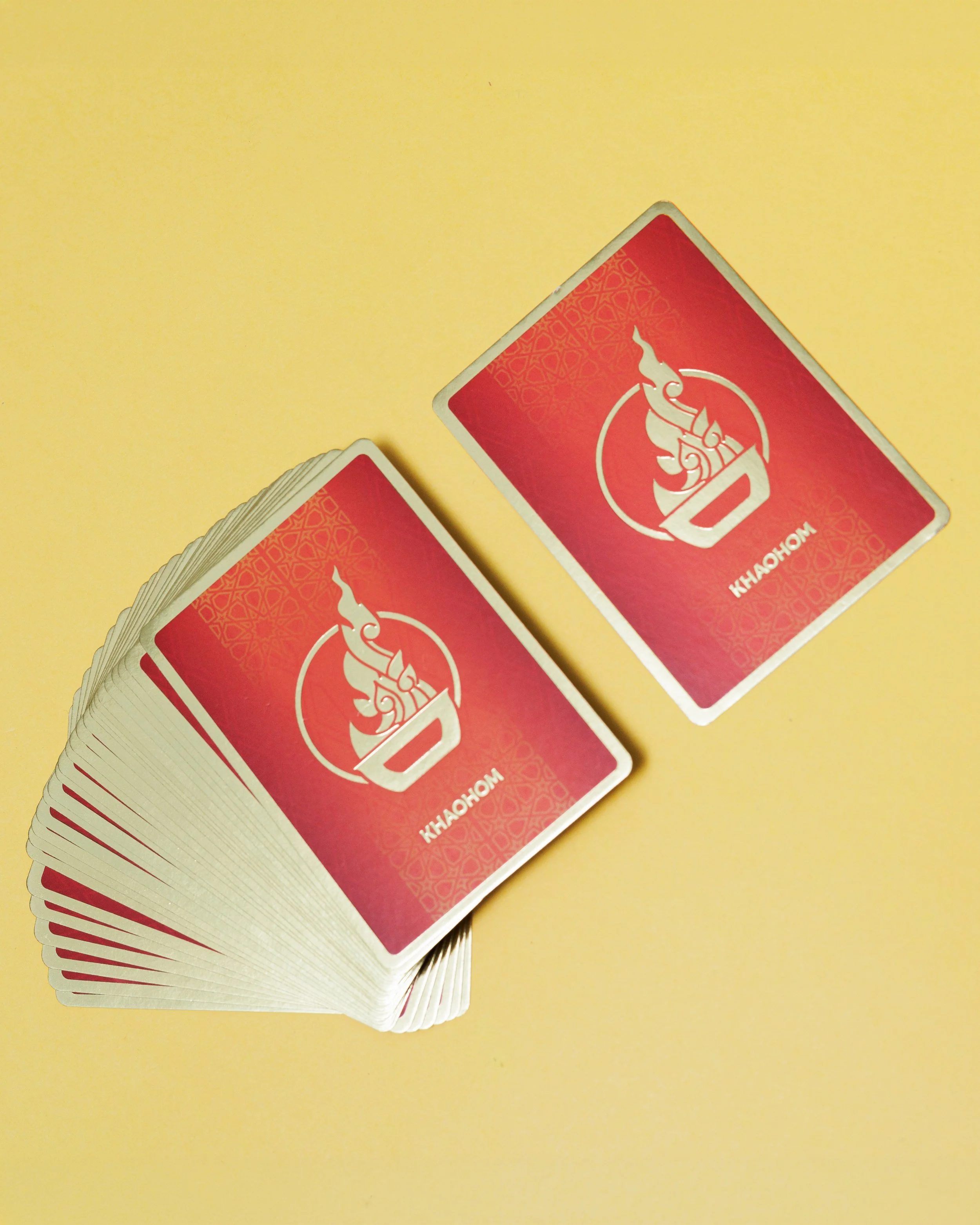 Khaohom custom playing cards with gold foil Thai flame emblem on red deck, corporate gift and event giveaway, retail merchandise Singapore