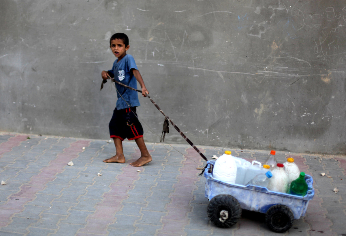 Palestinian child transporting his family's bottles, filled with potable water from a purification station, in Deir al-Balah central Gaza Strip, on May 22, 2013. (Photo: Ashraf Amra/APA Images) - 