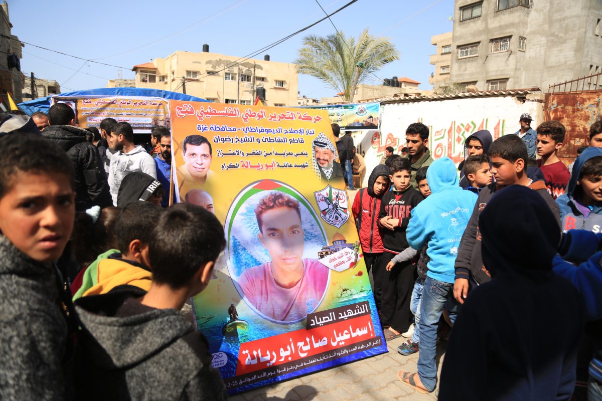 Children crowd around a poster of Ismail Abu Riyala. Photo:Messiah Gadzo 