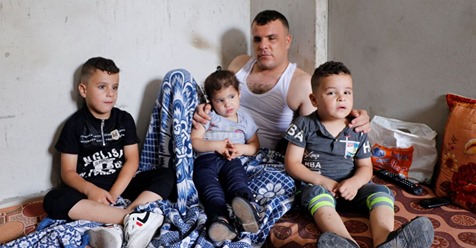 Khader al-Saaidy at home with his children. Their economic situation has become dire: He had been supporting 14 people in his extended family. He has nowhere to turn for help. Photo: Khaled al Azaiza