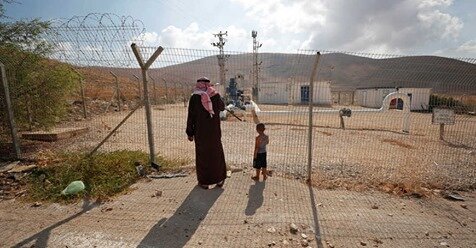 REUTERS/Mohamad Torokman Palestinians stand by a fence as they look at Israeli water pipes in the Jordan Valley, Israeli-occupied West Bank, Aug. 21, 2019.