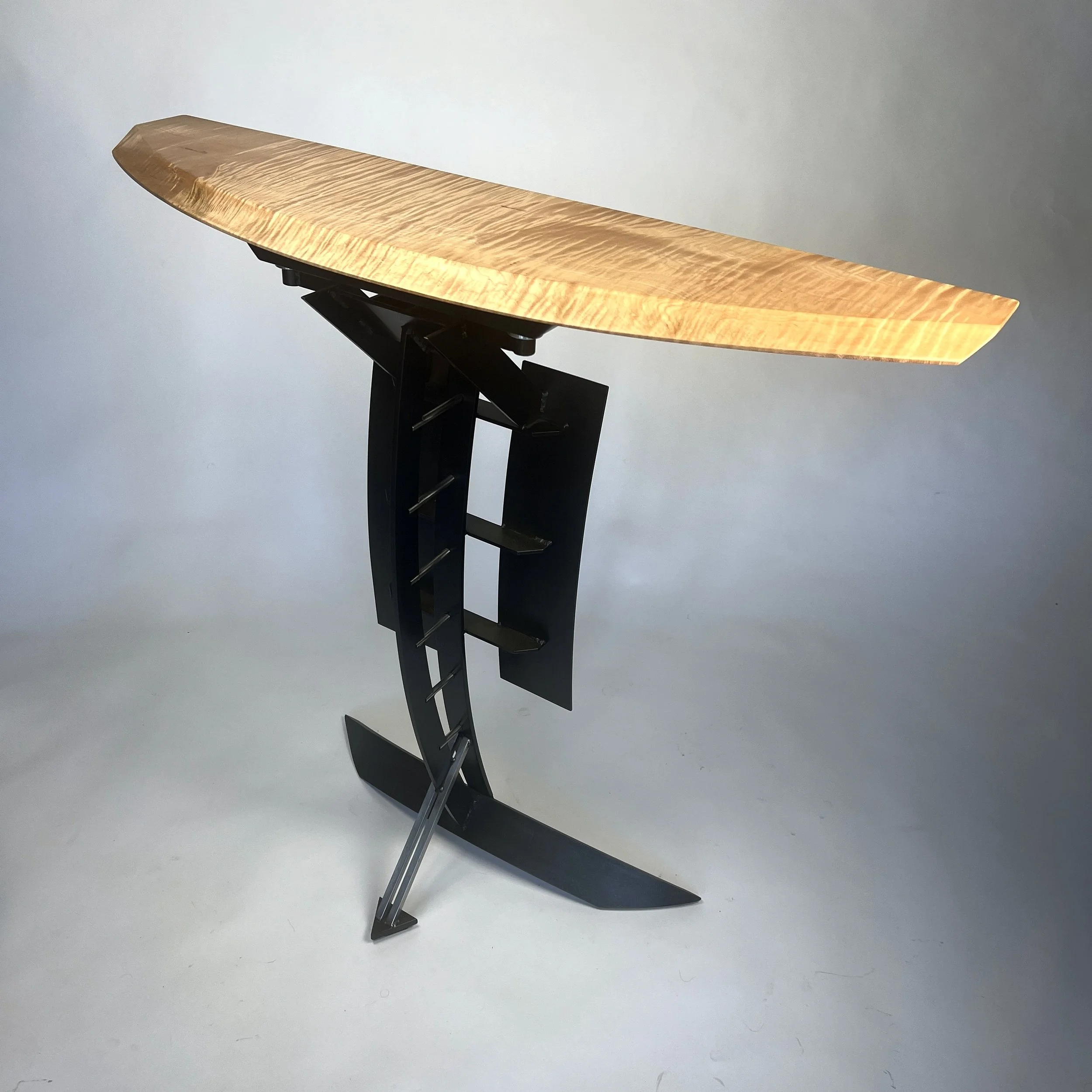  First Free Standing Metal Mast Demiloon   Console Table   Curly maple top is supported by rolled steel base alluding to a ships billows sails skimming above the water. 