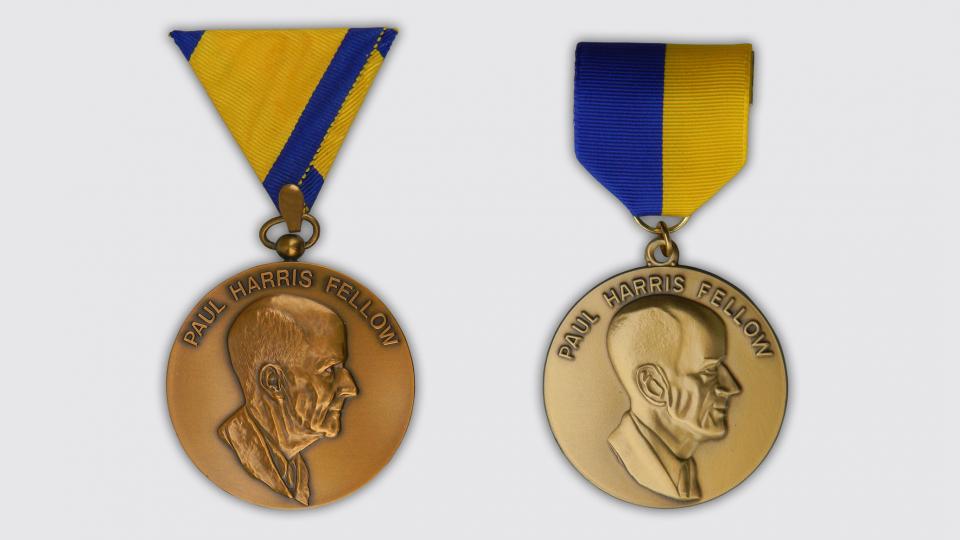 The first Paul Harris Fellow medallion (left) and a later version. Various lapel and neck ribbons were used with this medallion throughout the years.