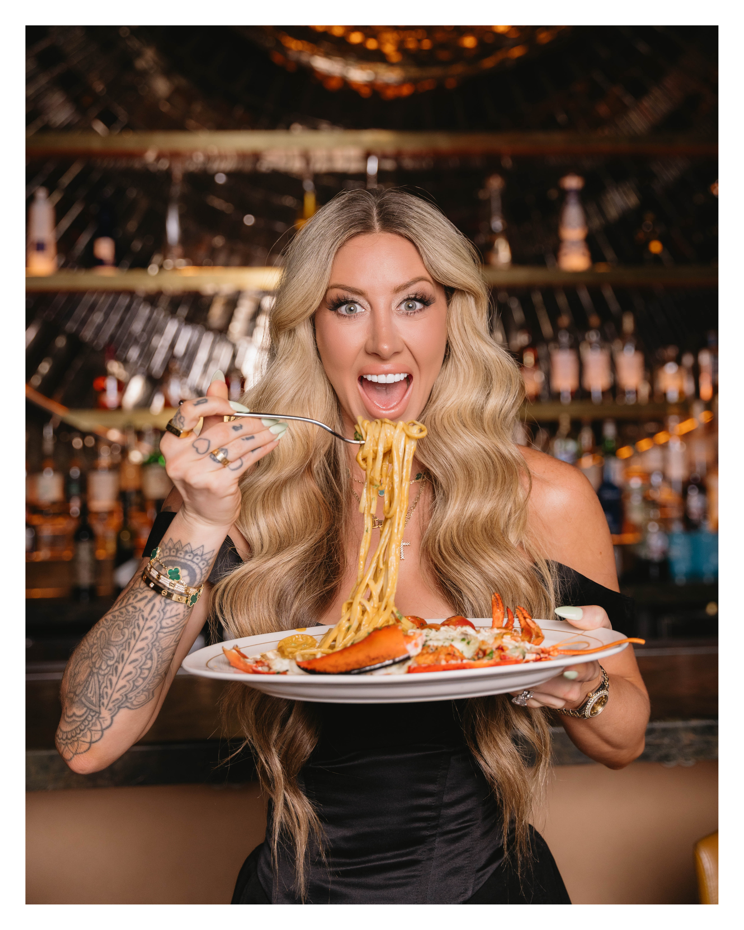 Guest twirling lobster pasta on a fork at the bar at EVELYN in the Dallas Design District