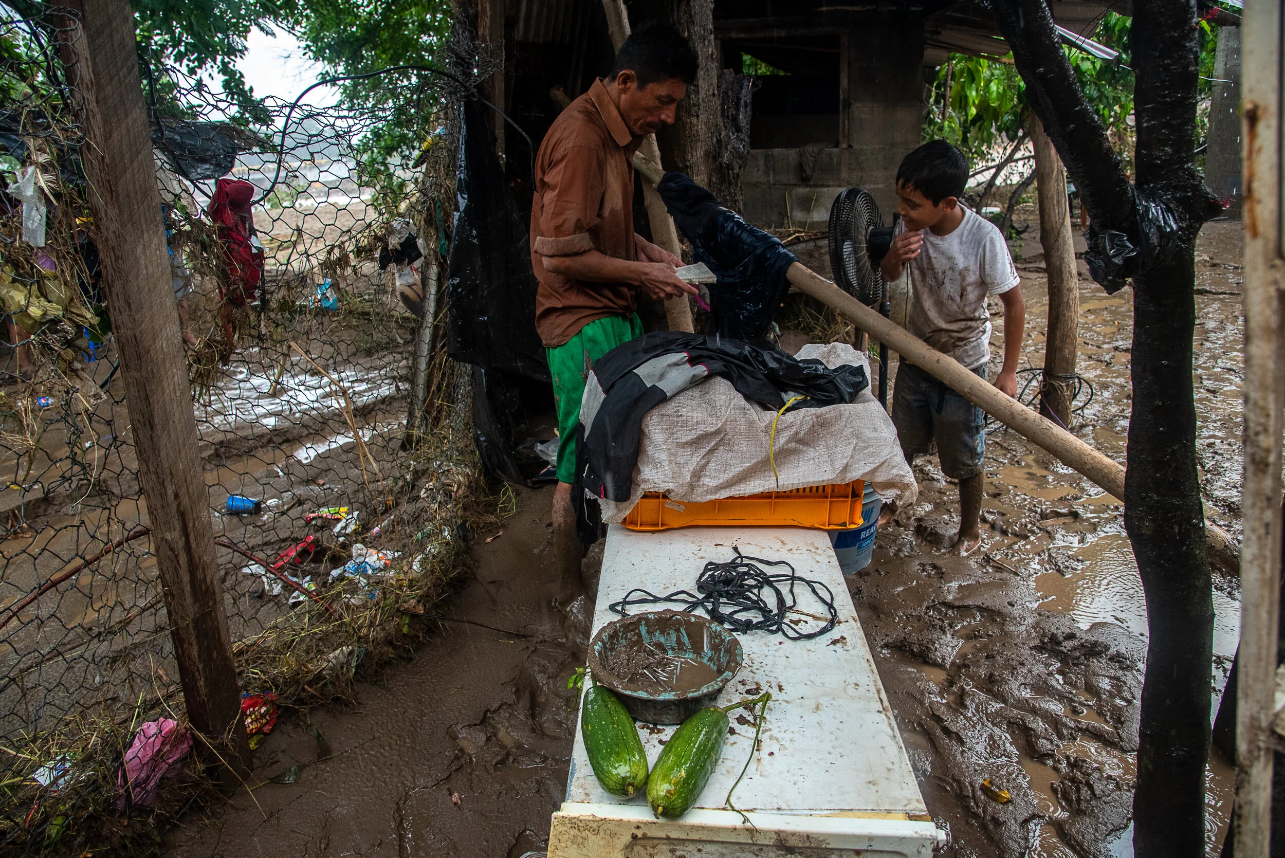  A father and son salvage their personal belongings after a flood destroyed their home in San Pedro Sula, Honduras. Flooding in the aftermath of Hurricane Eta has displaced hundreds of thousands in Honduras. There are many missing people and the deat