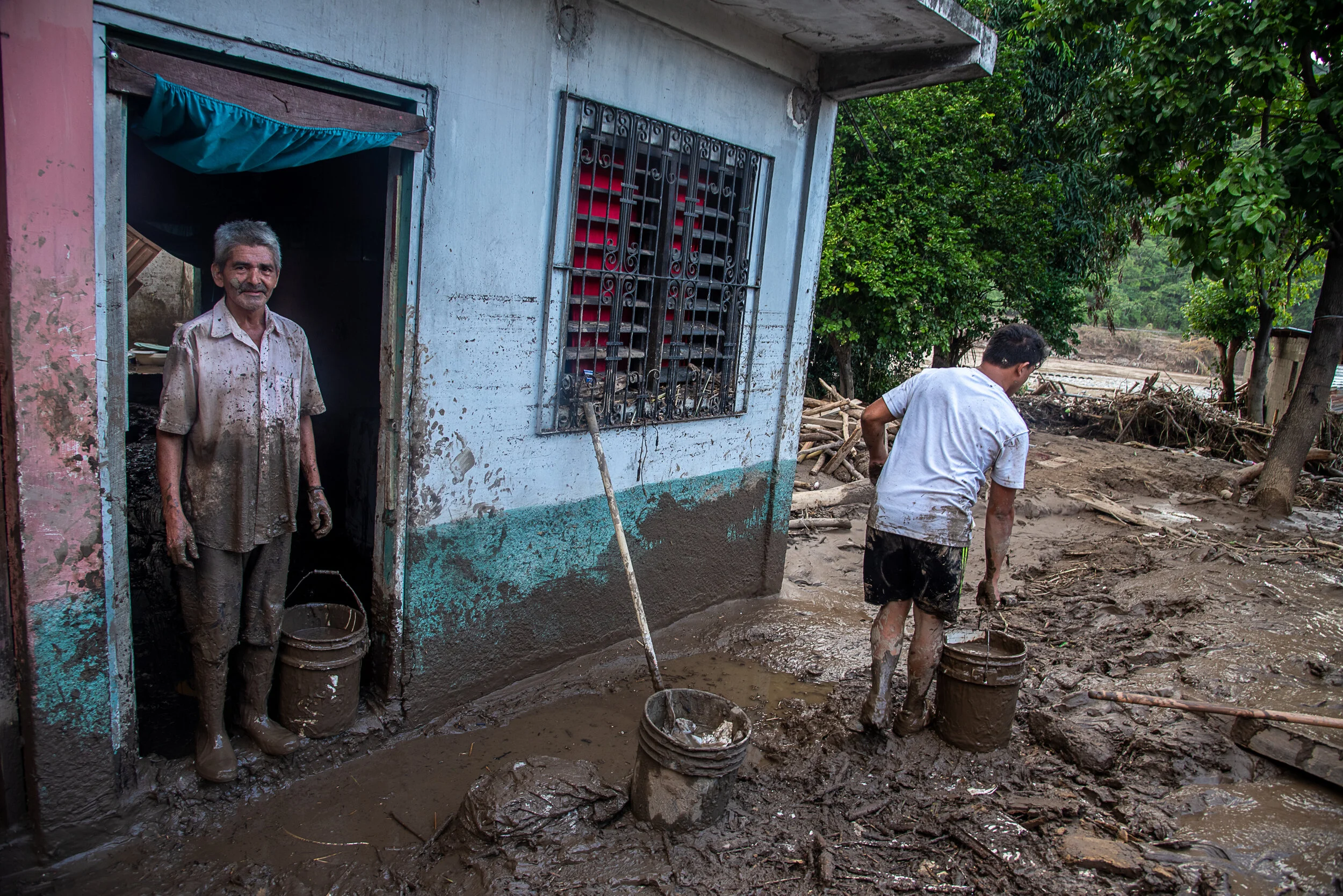  A father and son clean the mud from thier home after the Chemelecon river flooded and destroyed many homes in San Pedro Sula, Honduras. 