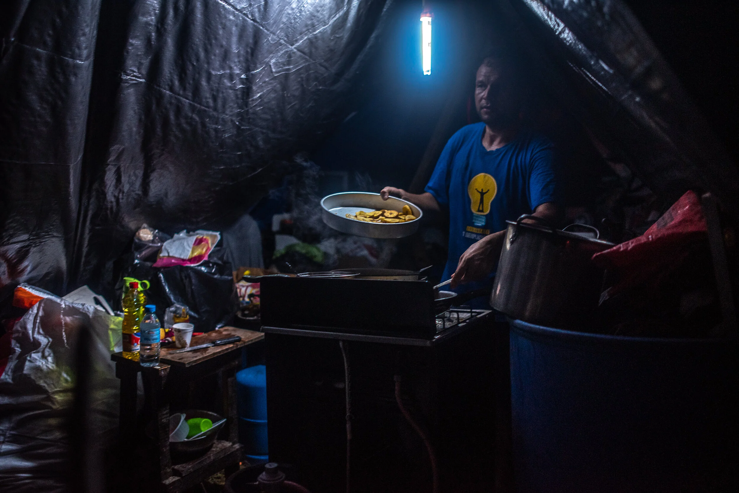  A man cooks plantains in a refugee camp after Hurricane Eta left hundreds of thousands displaced in San Pedro Sula, Honduras. 