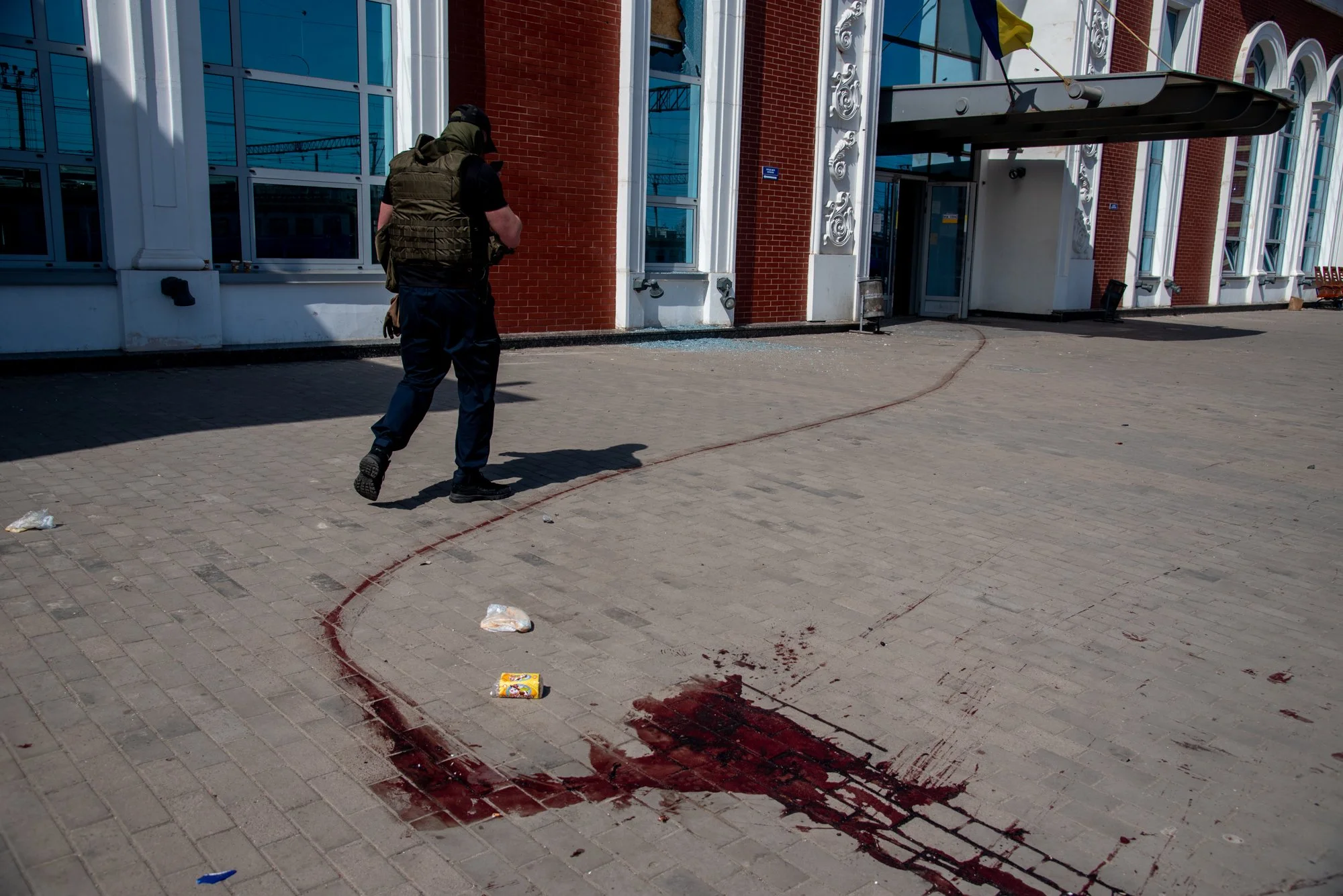  A Ukrianian soldier walks by blood stains at the Kramatorsk train station where a Russian missile attack killed fifty-seven and injured hundreds. 