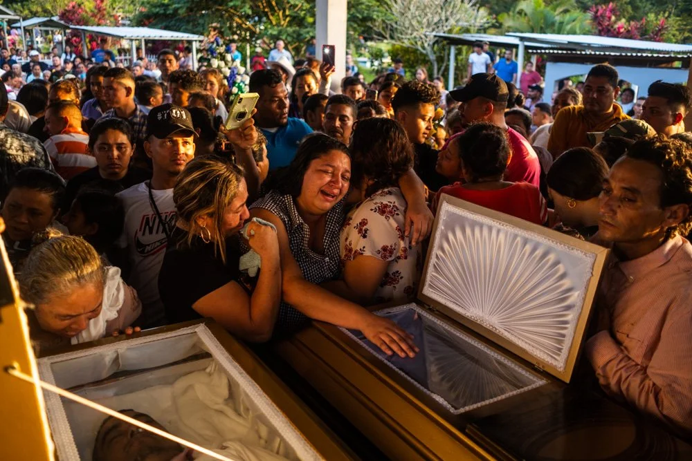  The girlfriend (right) of Jairo Bonilla and mother (left) of Aly Domínguez wheep over the caskets of the murdered environmentalists in Guapinol, Honduras. 