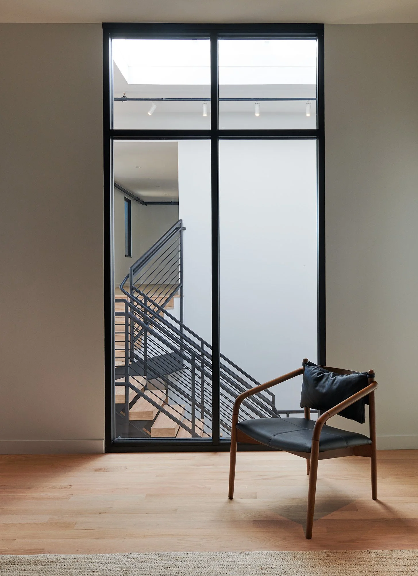 A quiet moment of repose overlooking the stair at MODE4’s Pivoting project. The stair creates movement through the center of the home, while the framed opening and solitary chair create a place to pause, sit, and observe.