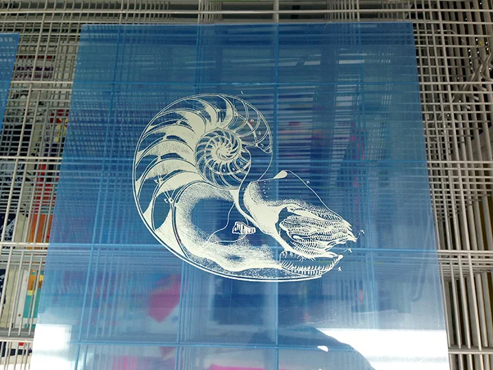 The graphic printed on the acrylic sheet is on one side. It is attached to the wood panel (and photo) printed side down.