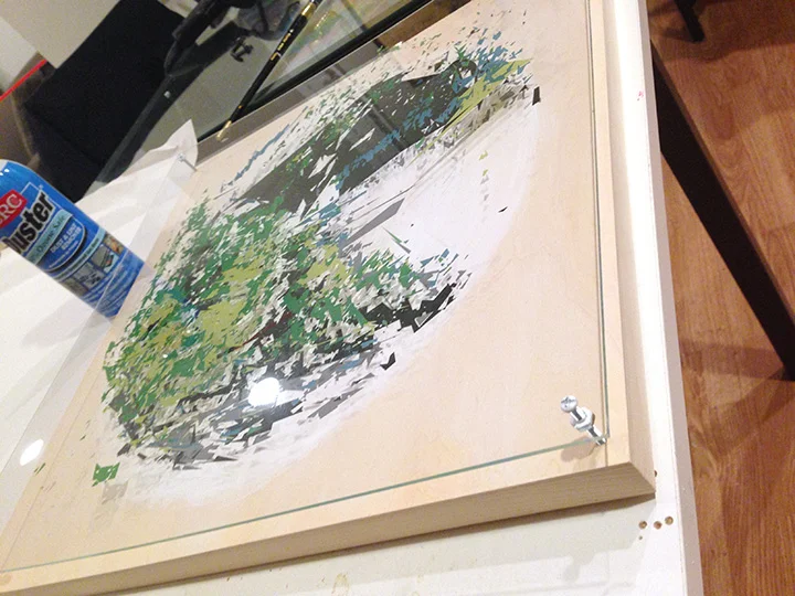 The plexiglass and wood panel are clamped together, then drilled holes to affix them together with the painted hardware.