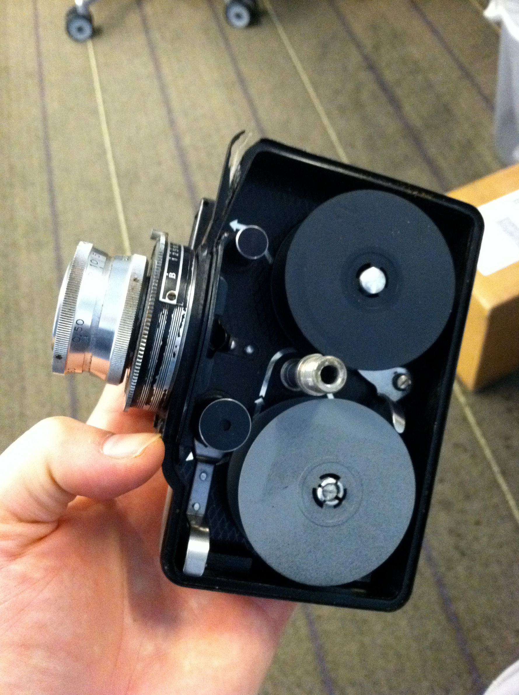 The side opens and the film is loaded like a movie camera, threading the film through a film gate and into the take-up spool.