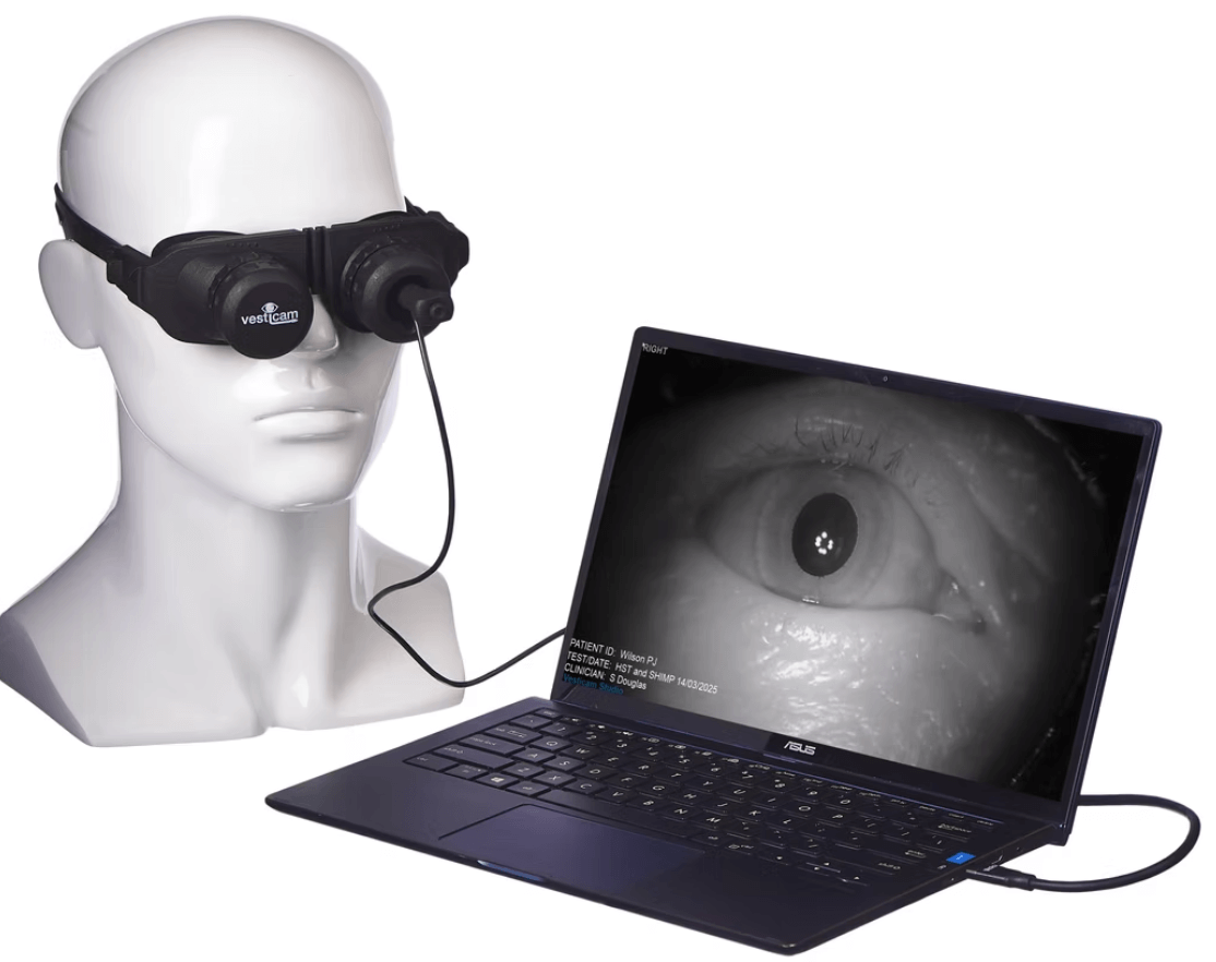 A mannequin wearing snorkeling goggles connected to a laptop displaying a close-up of an eye in black and white.