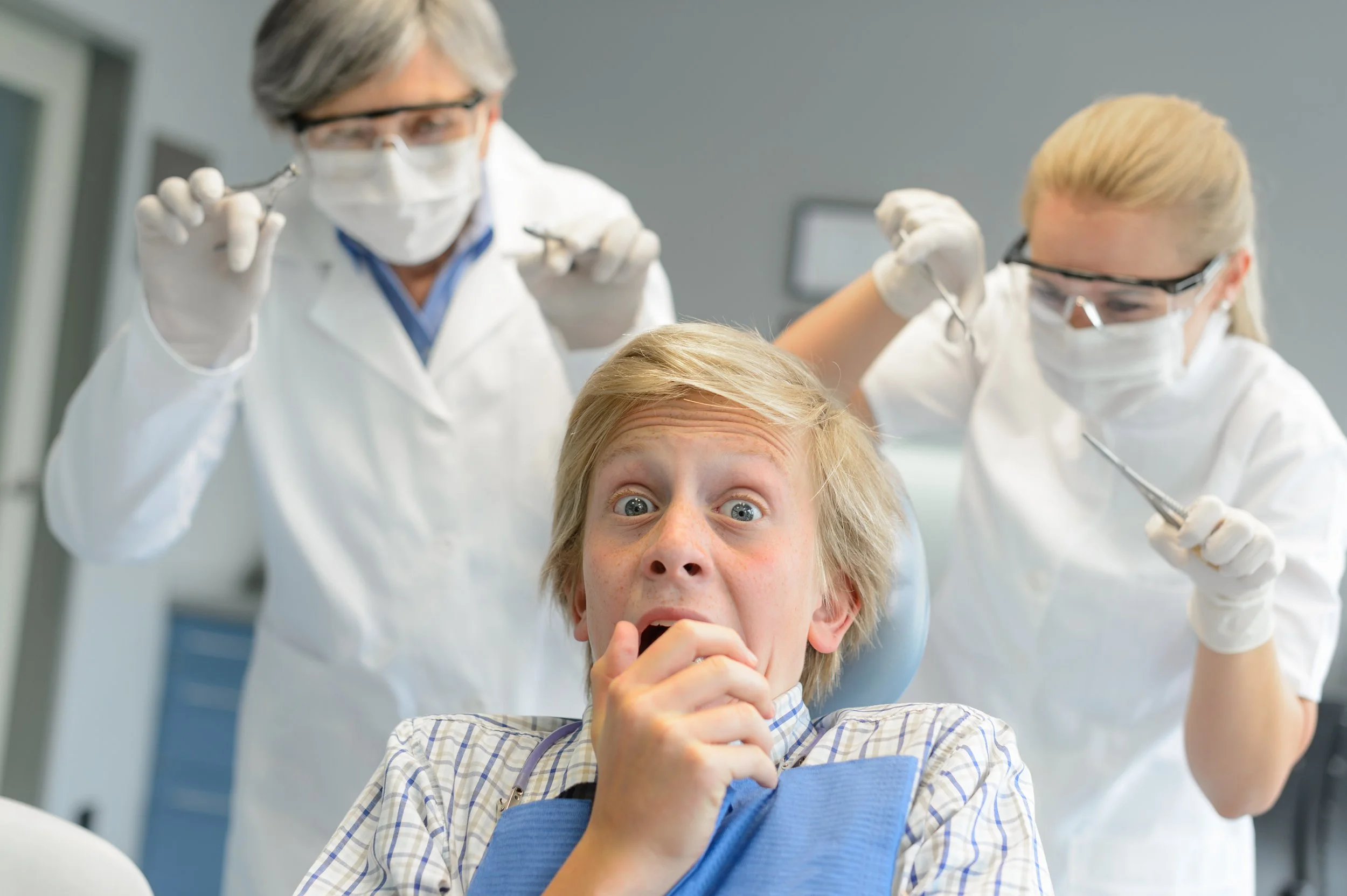 scared-teenage-patient-boy-at-dental-clinic-frightening-dentist-assistant-SBI-300904923.jpg