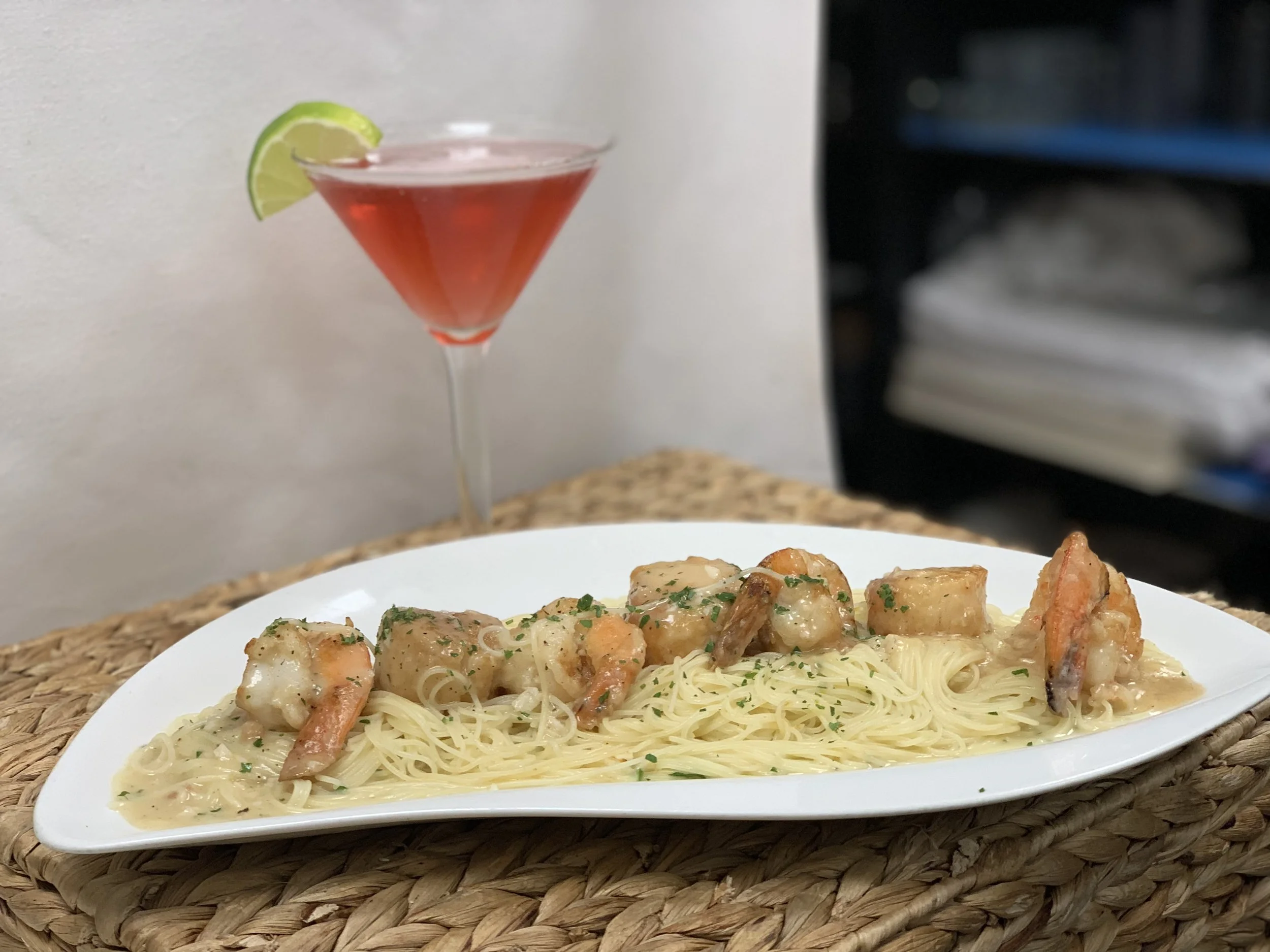 Pictured here is our shrimp and scallop scampi! This customer ordered our dish over angel hair pasta and it was accompanied by one of our ice cold cosmos!