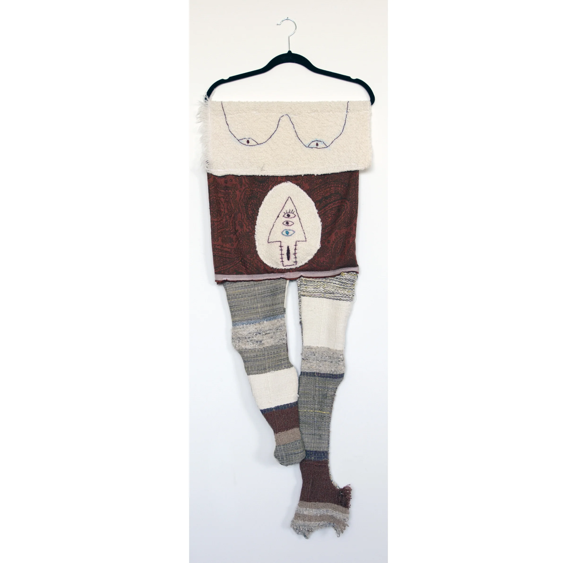 Figure 1: My Eyes Are Down Here: White , Hand-woven and machine-made fabric, embroidery, coat hanger, 53 x 18 inches