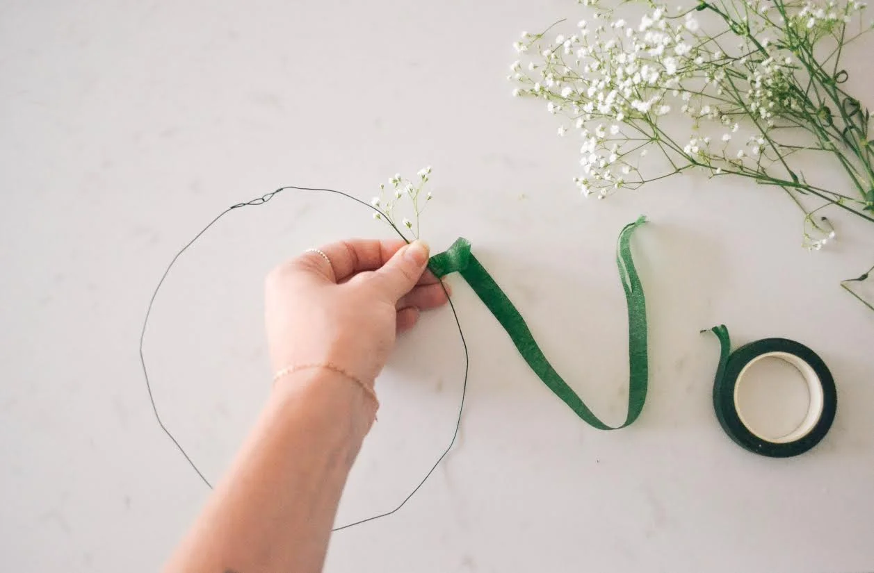Start on one side of the wire as far down as you choose. Hold the snipped piece of flower alongside the wire and start wrapping the flower tape around it until it feels secure.