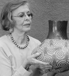 Marti, looking at a piece of pottery by Santa Clara artist Jody Naranjo