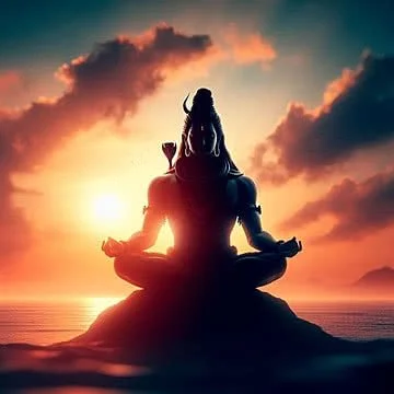 Silhouetted figure meditating on a rock at sunset over the ocean.