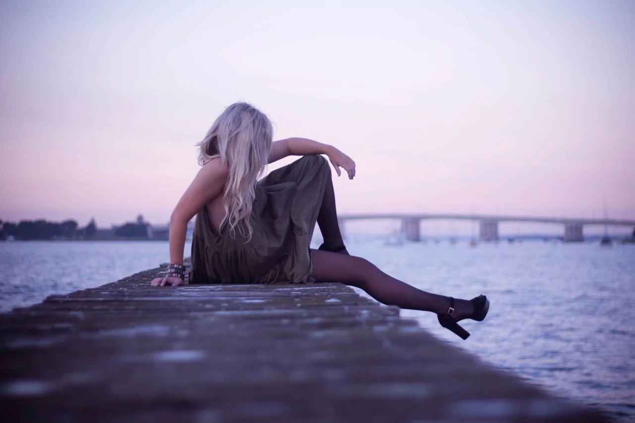young girl sitting on wharf