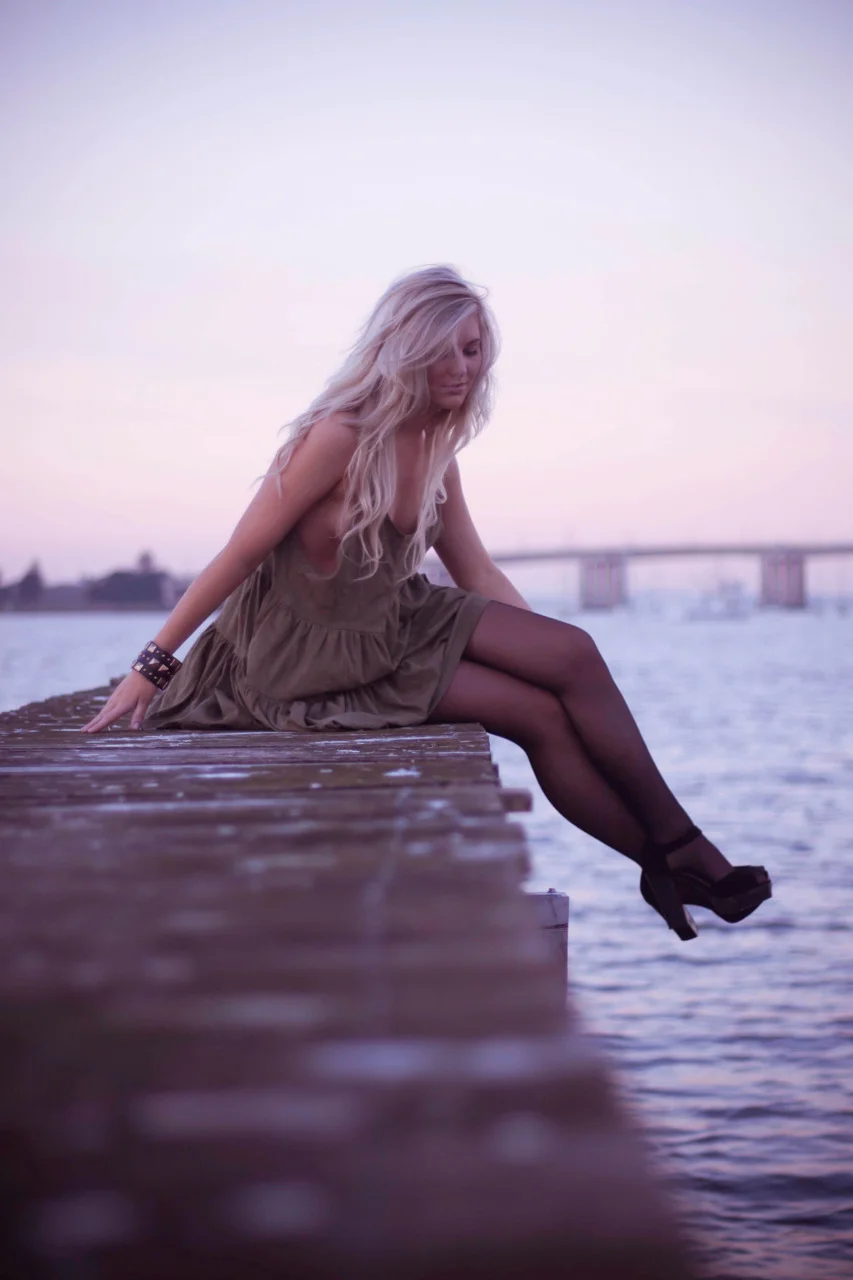 young girl sitting on wharf