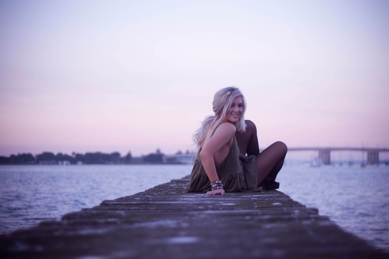 young girl sitting on wharf