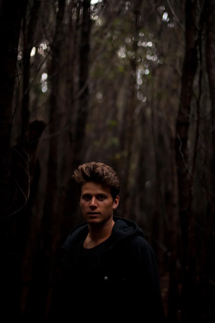 man standing in forest in black shirt