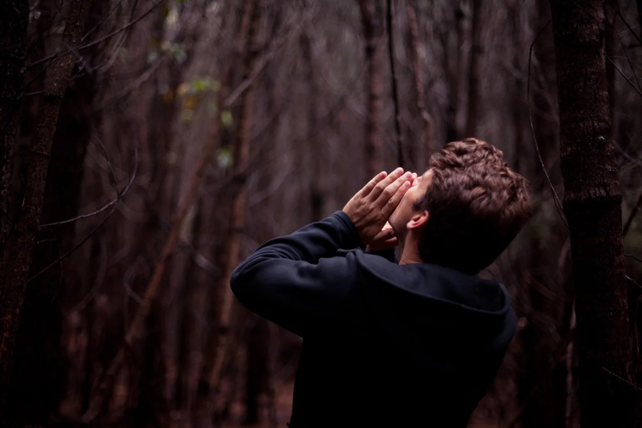 man standing in forest in black shirt