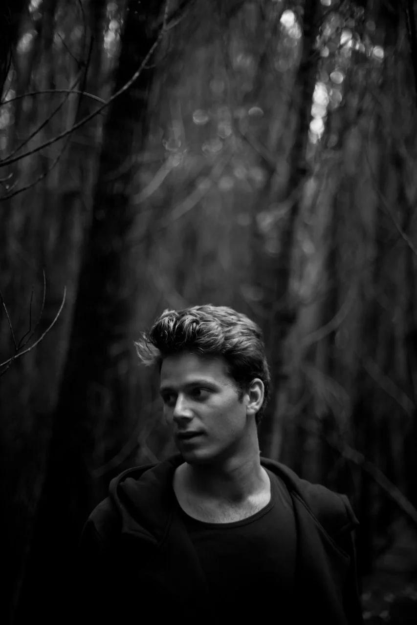 man standing in forest in black shirt