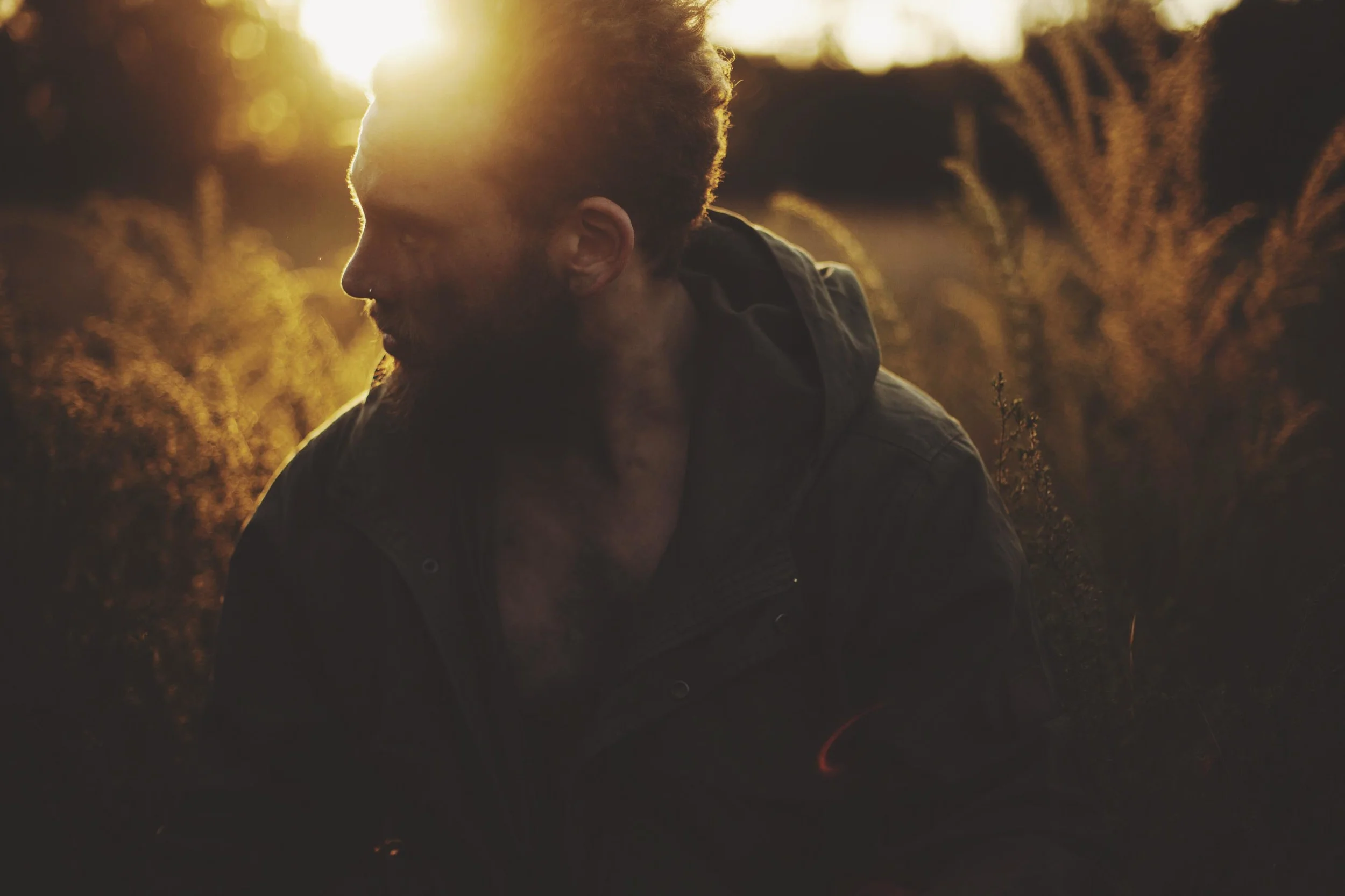 man standing in forest in golden light