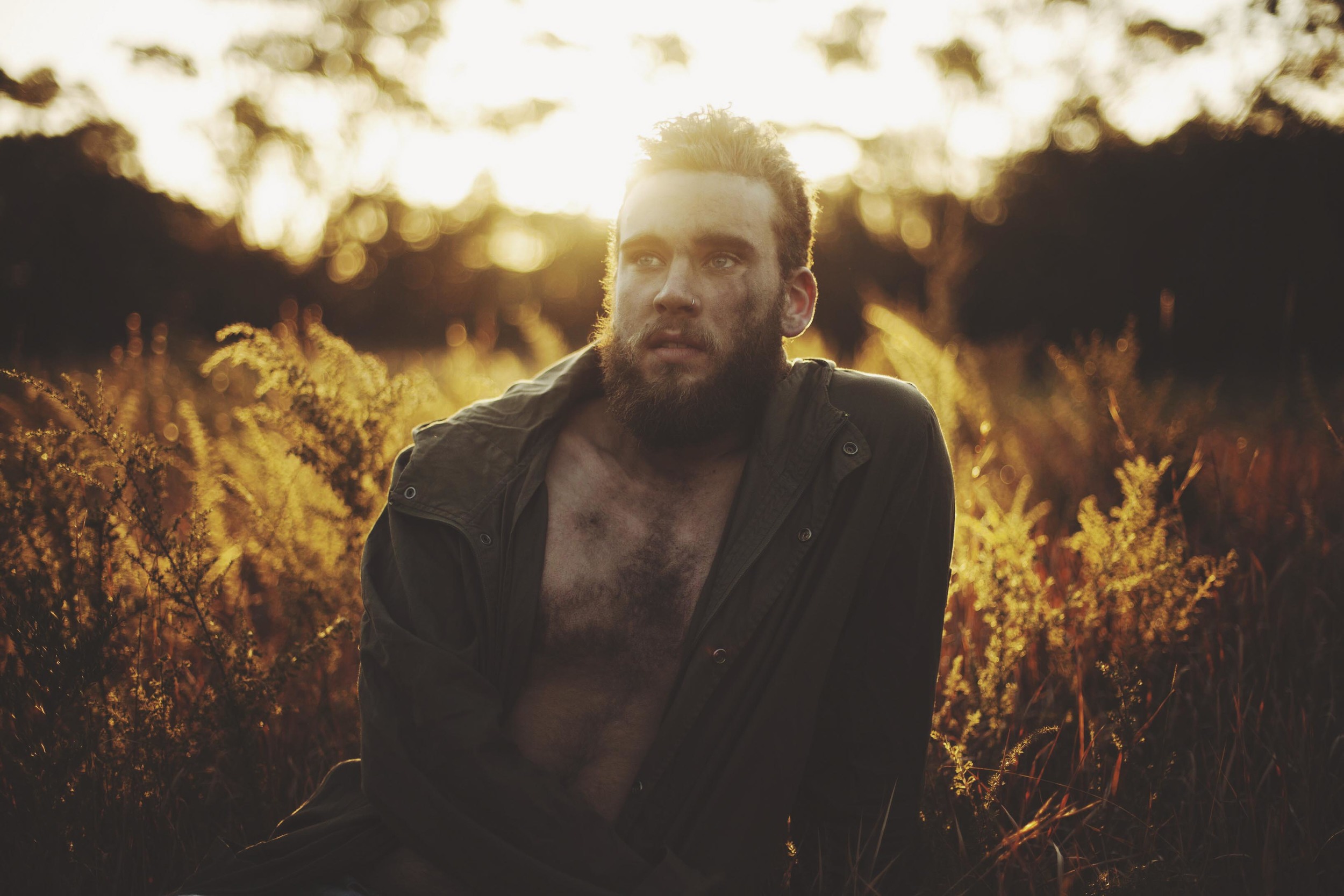 man standing in forest in golden light