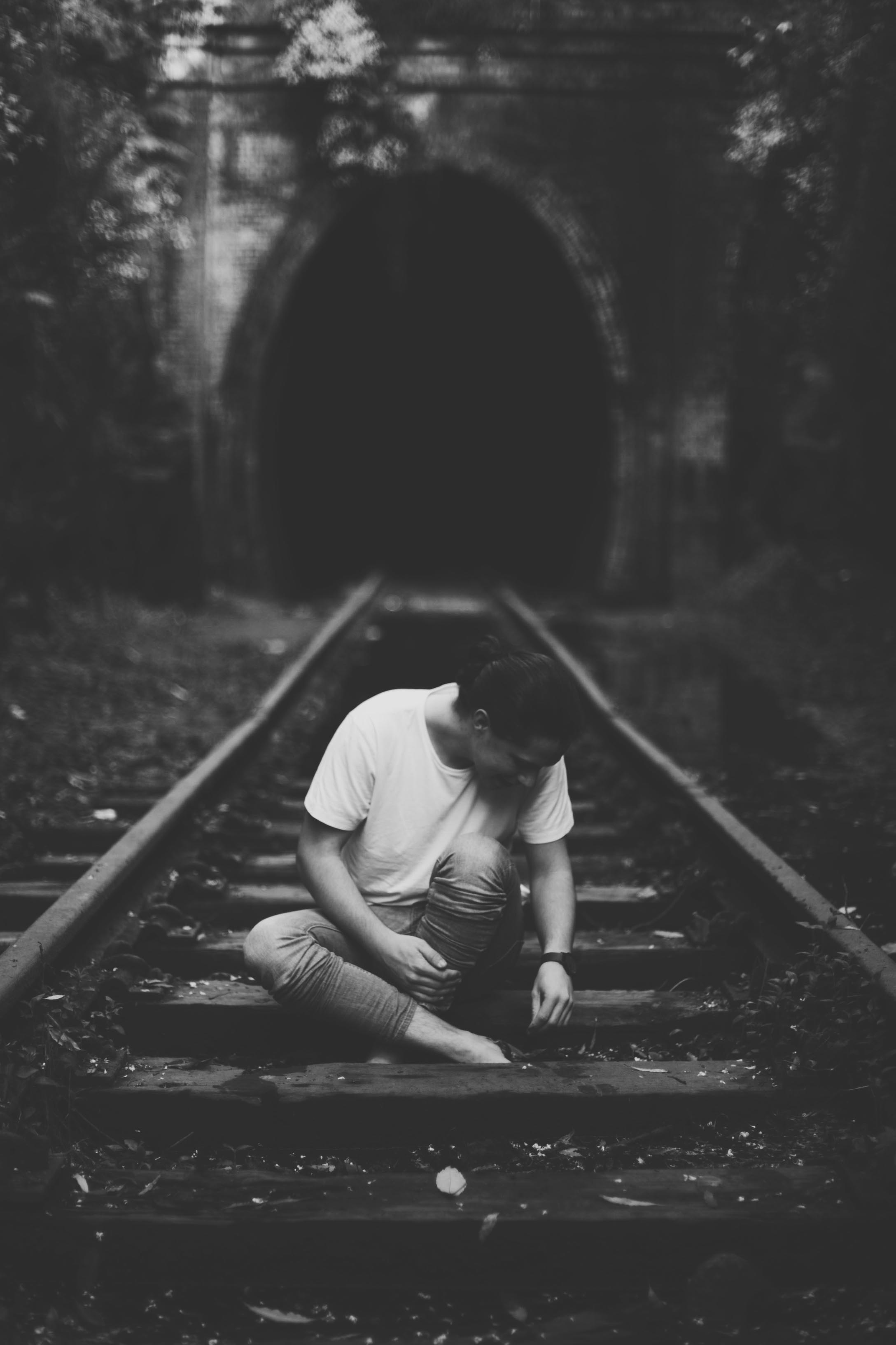 man standing in rainforest with guitar