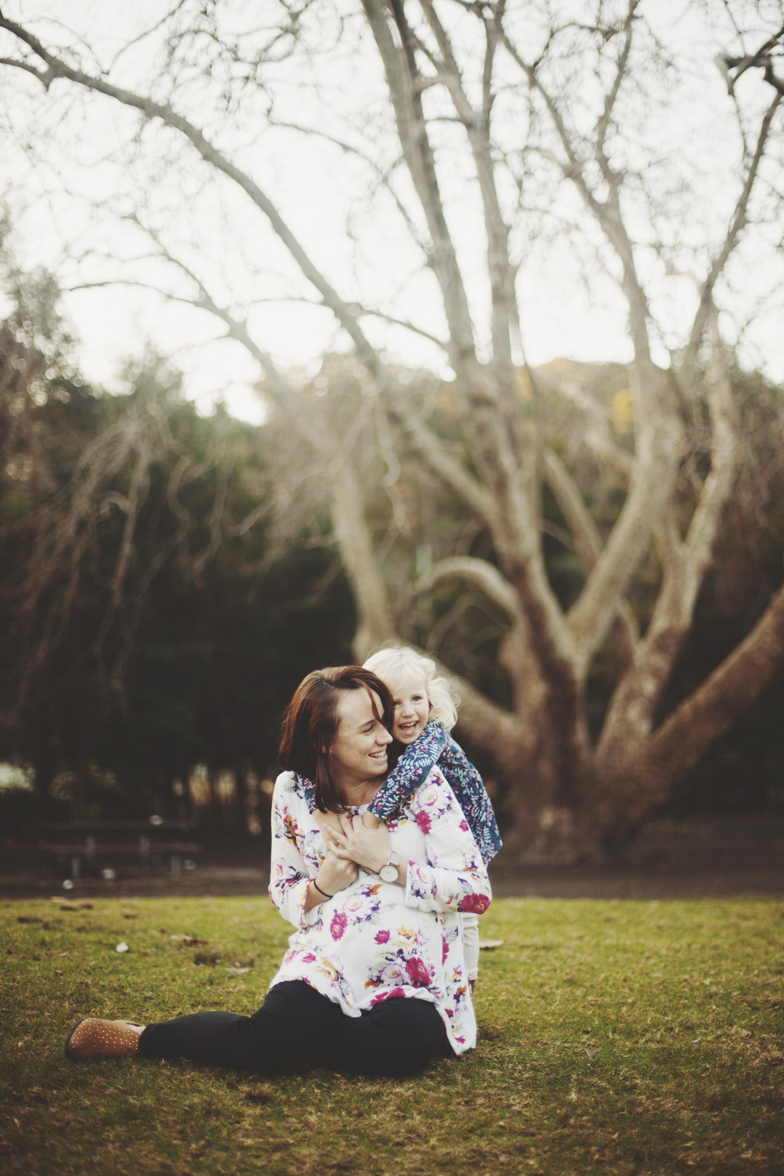 mother and daughter laughing on grass