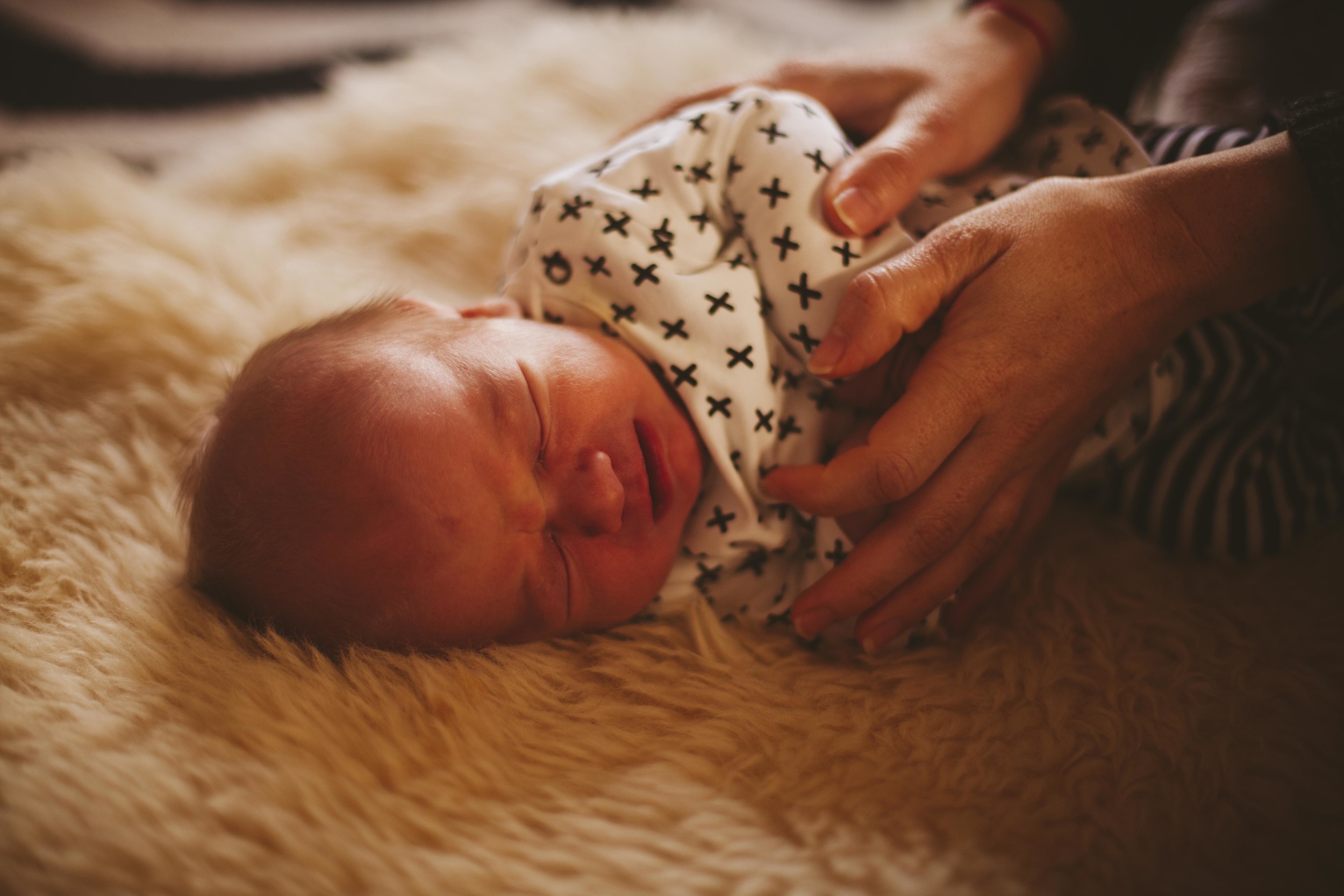 newborn baby laying on floor 