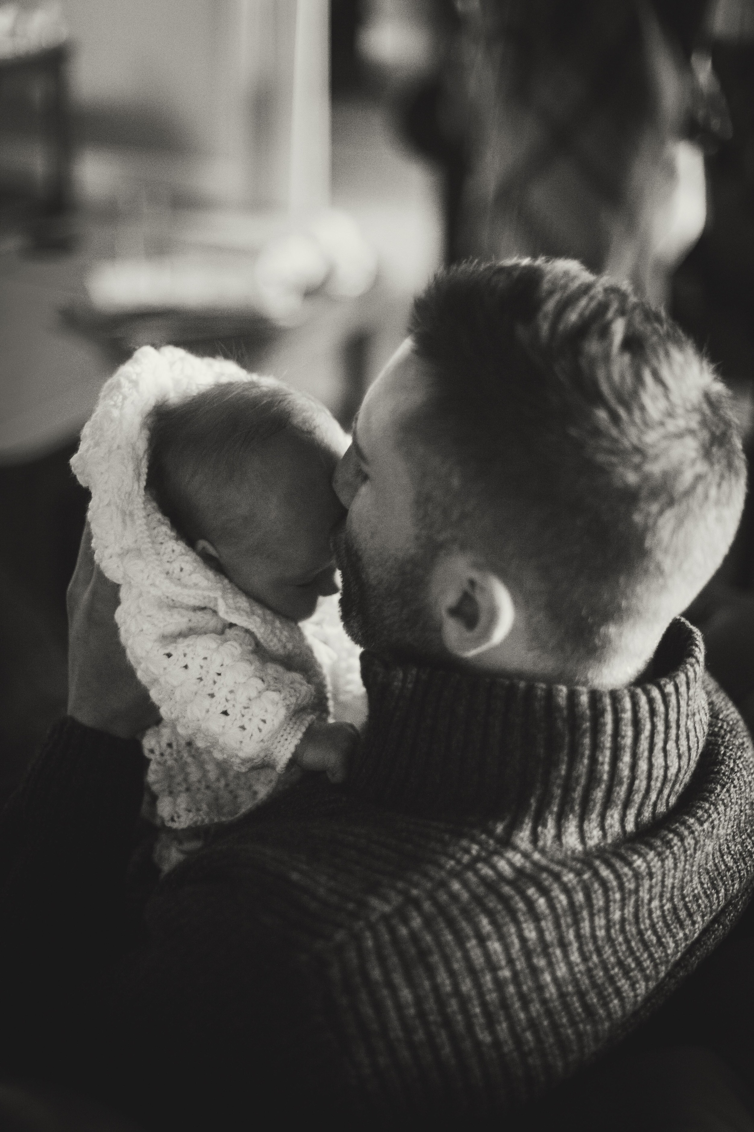 father smelling newborns forehead