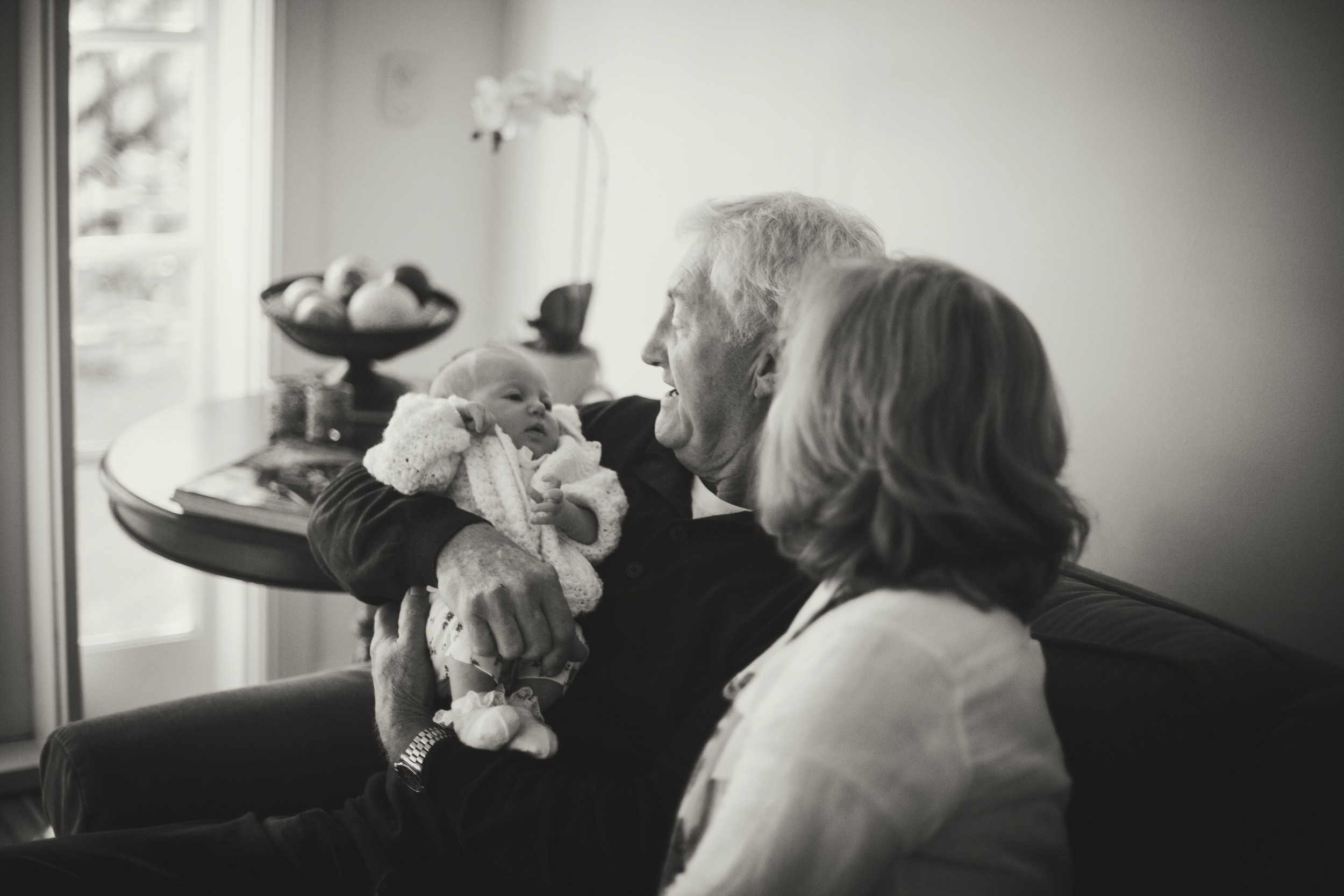 grandparents holding newborn