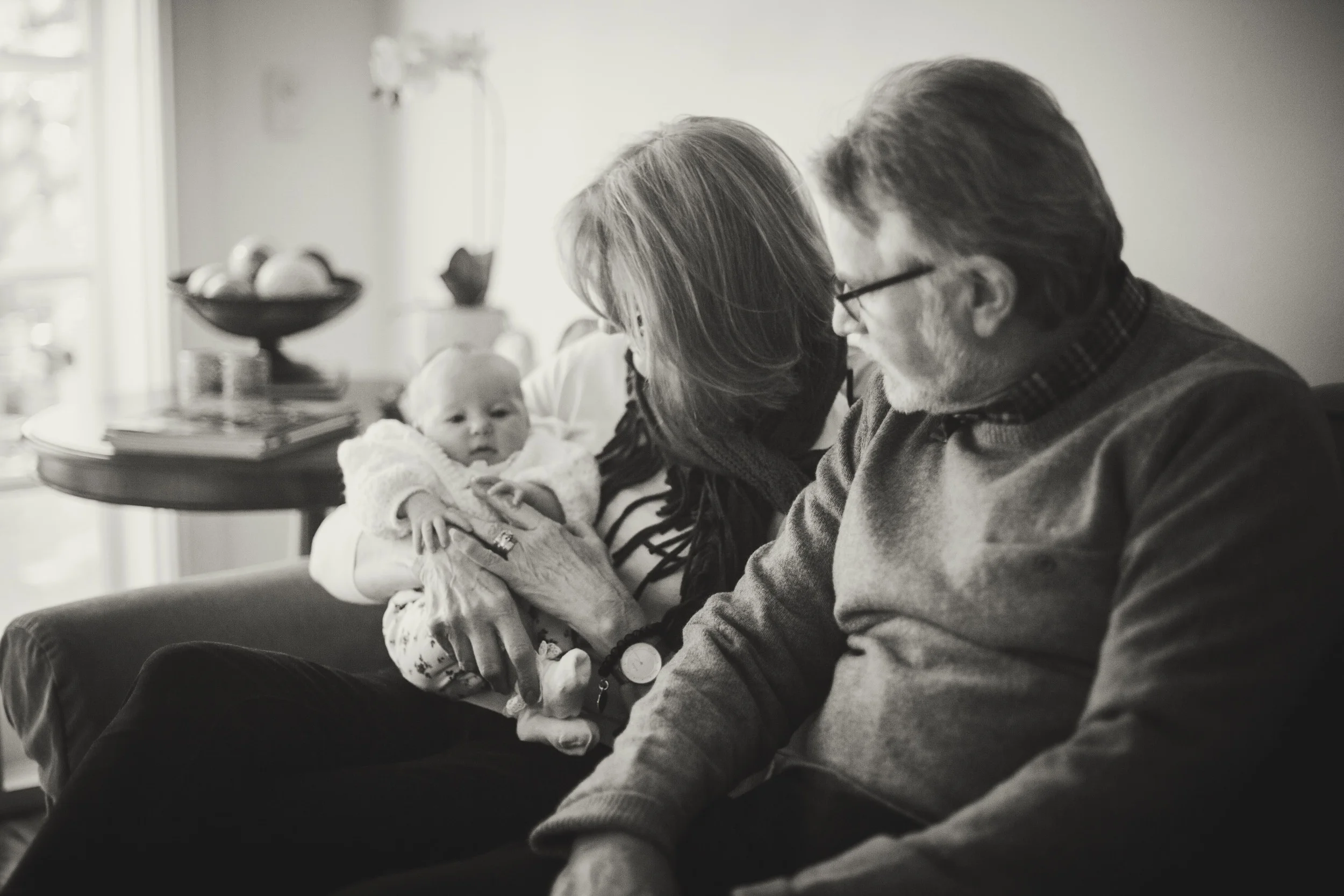 grandparents holding newborn baby