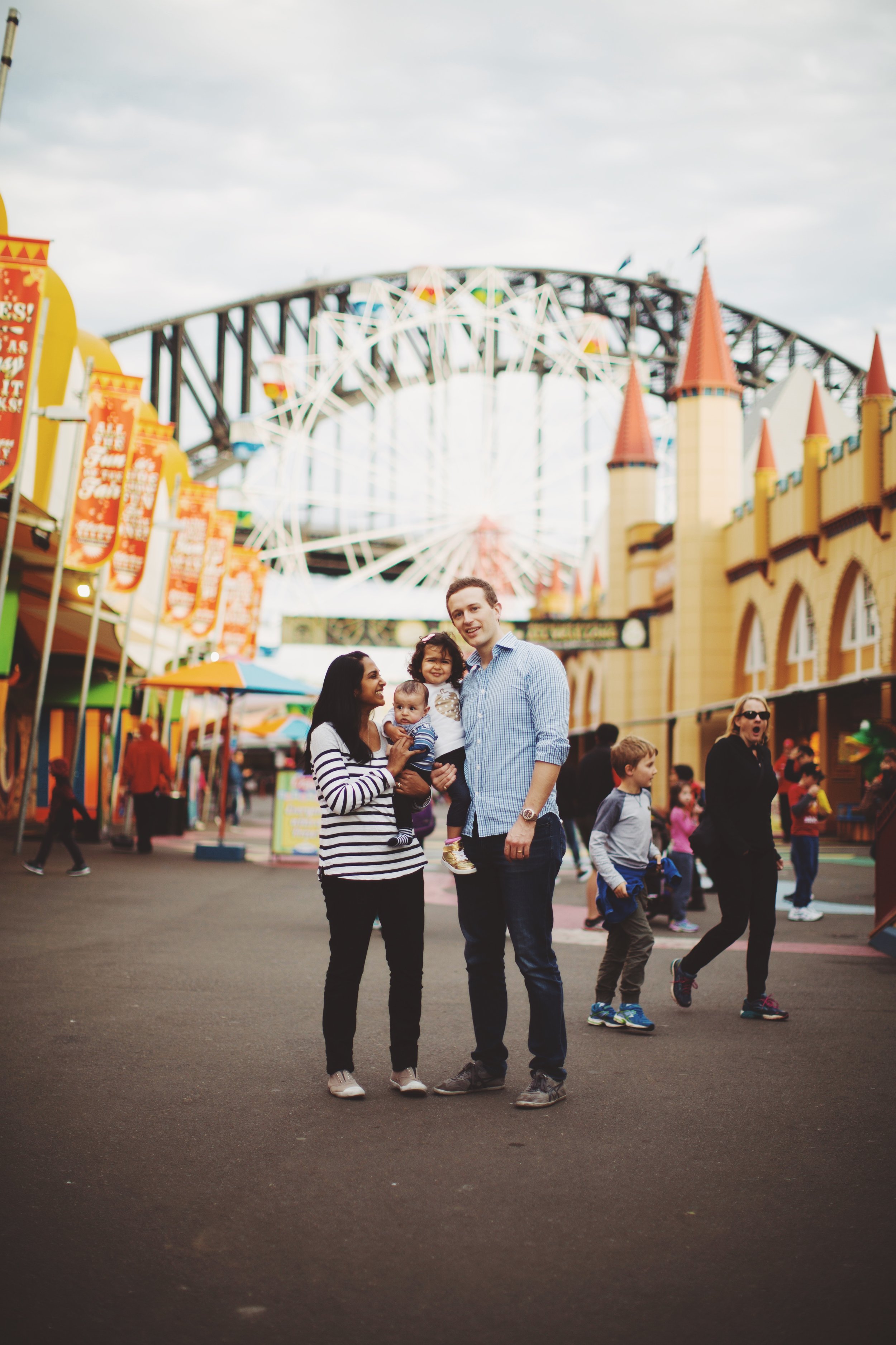 family of four standing in luna park in sydney