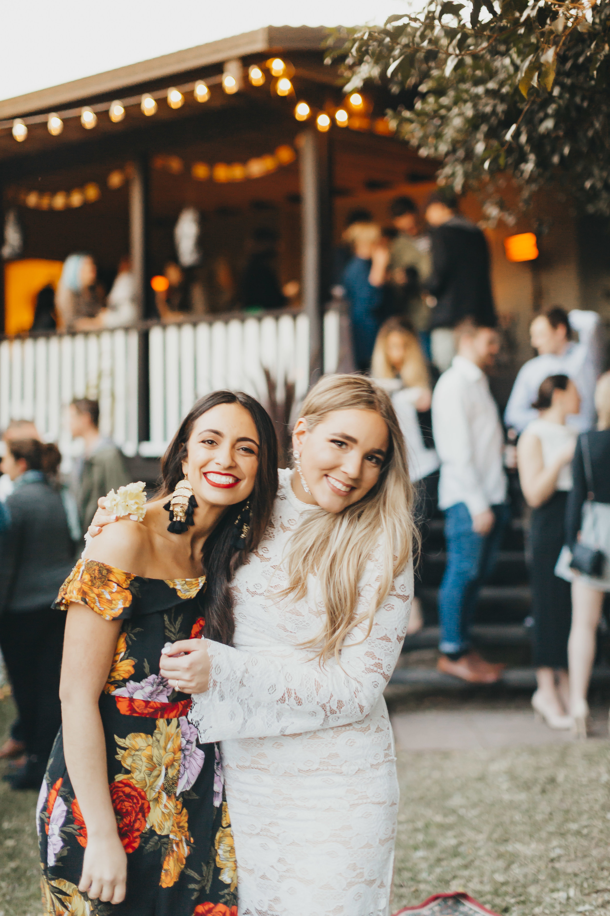 Two young women at party smiling at camera