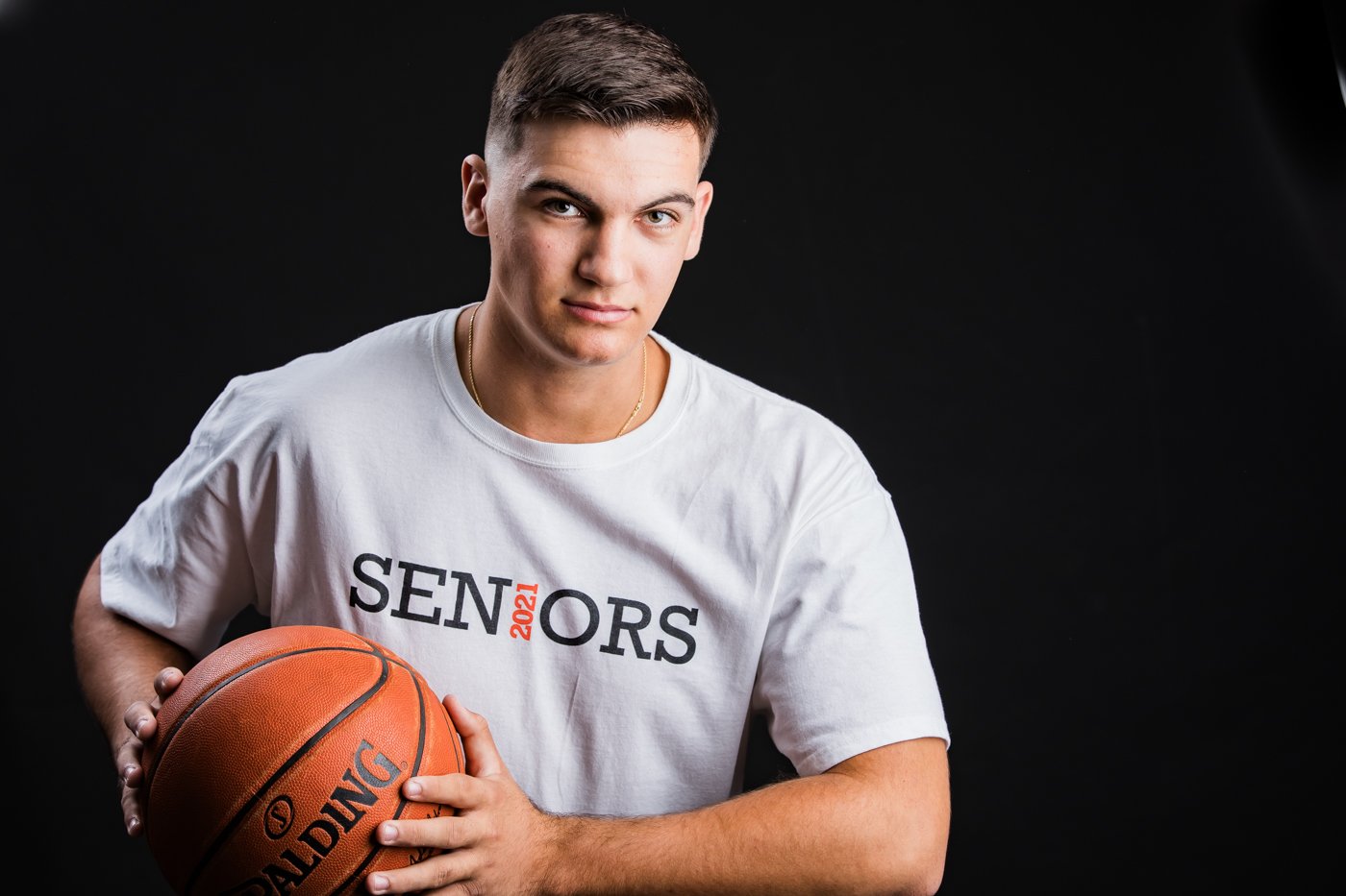 A yhigh school senior in a white T-shirt with