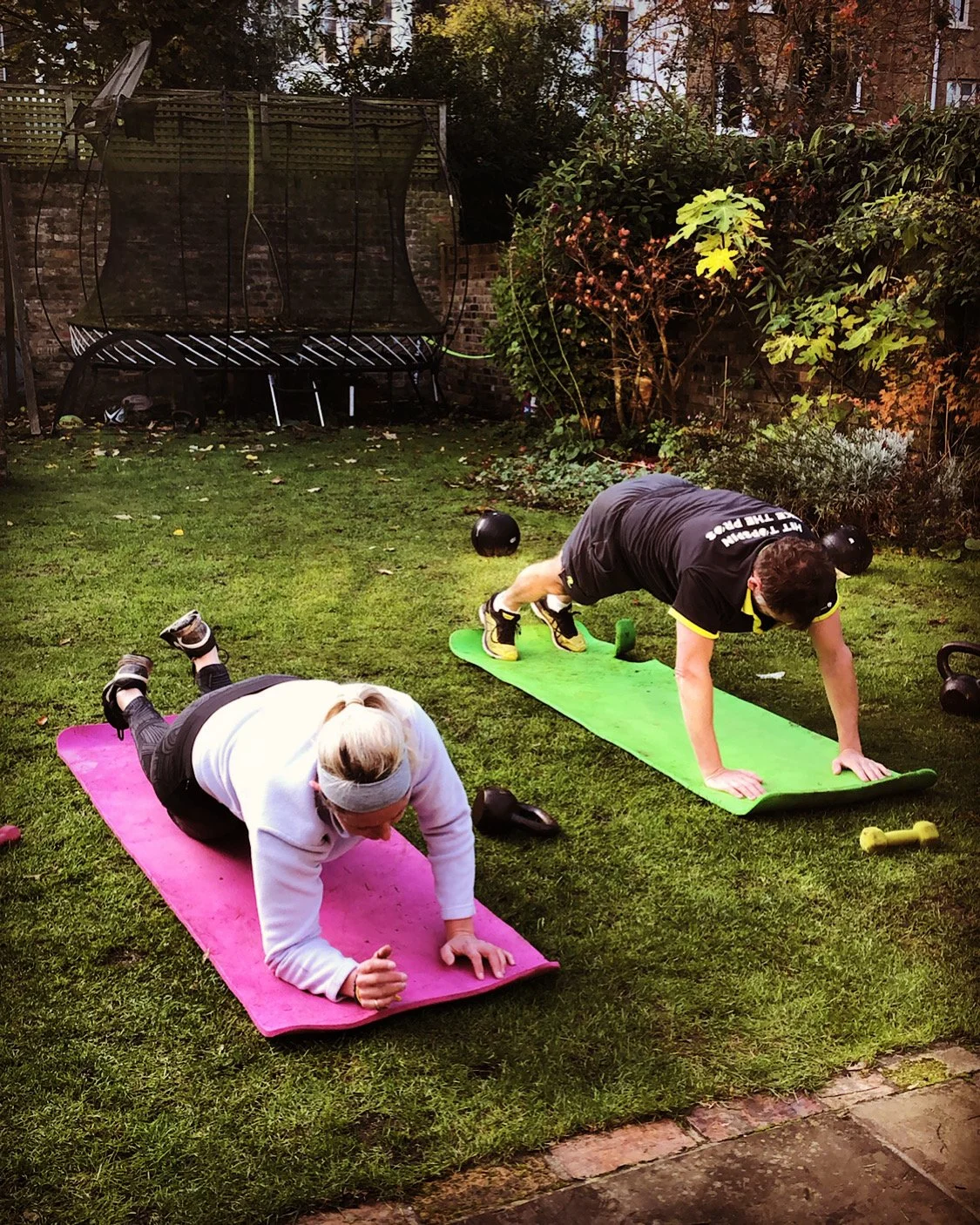 Client holding a plank position during an outdoor personal training session in Battersea Park with PT Zara Smalley