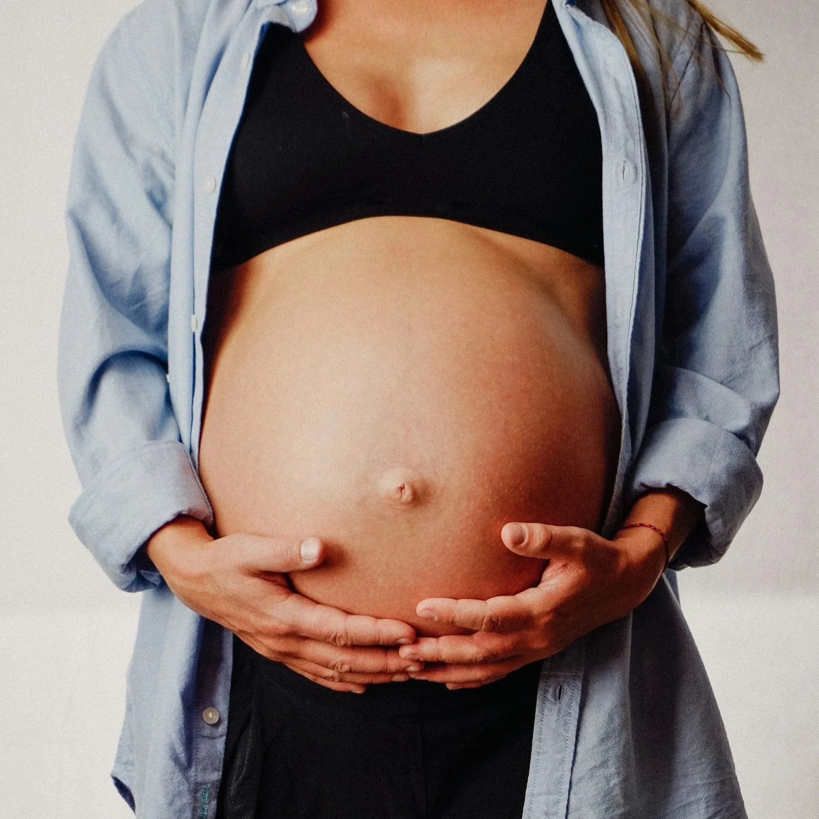 Pregnant woman with a bump training safely with a pre and postnatal personal trainer in South West London