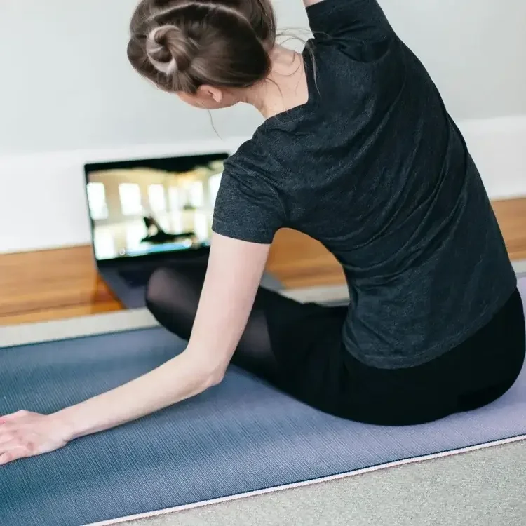 Woman completing a home workout as part of an online personal training programme