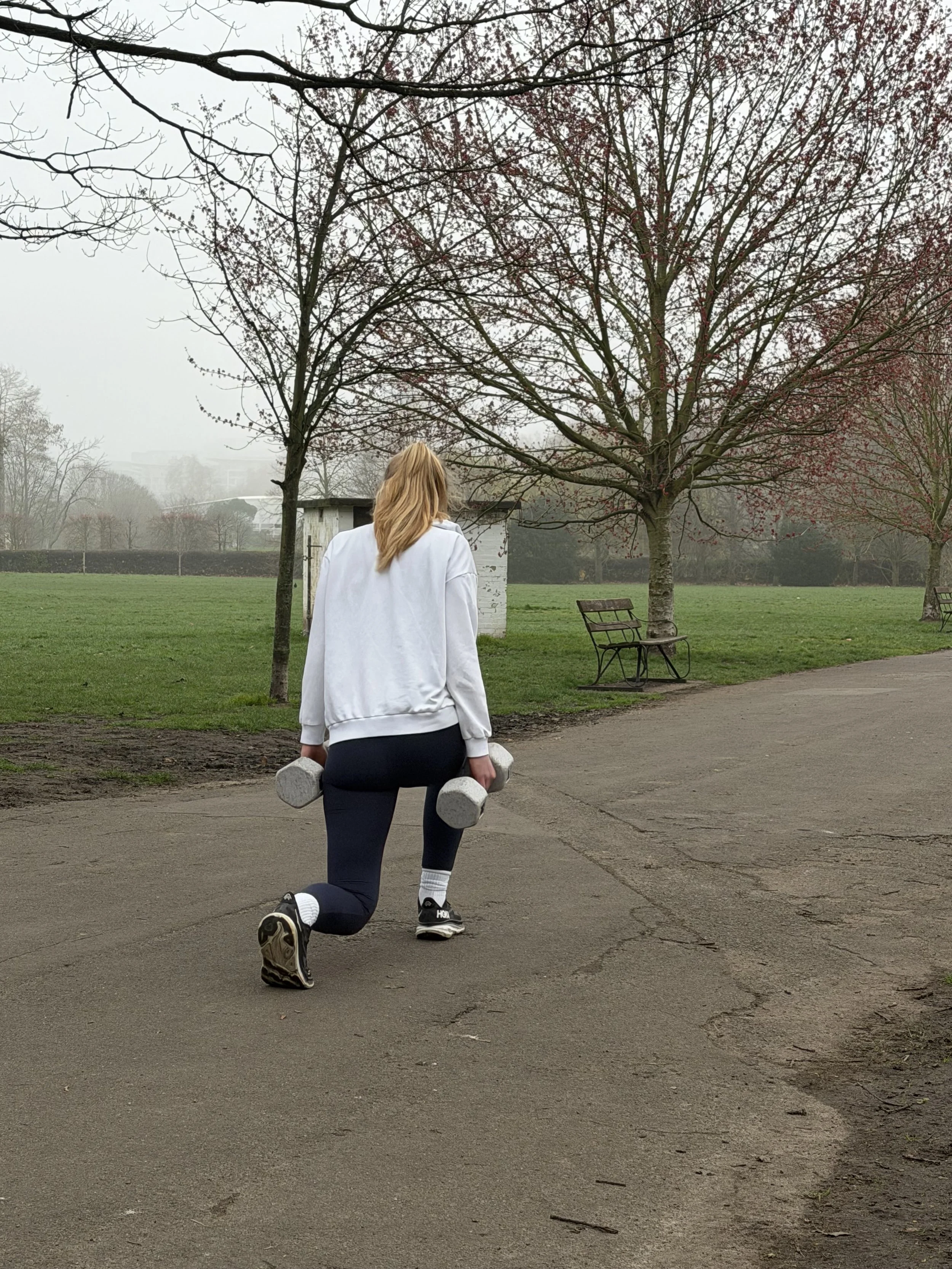 Personal trainer Zara Smalley demonstrating walking lunges in Battersea Park