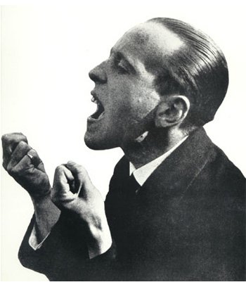 Photograph of John Heartfield yelling his audience awake.