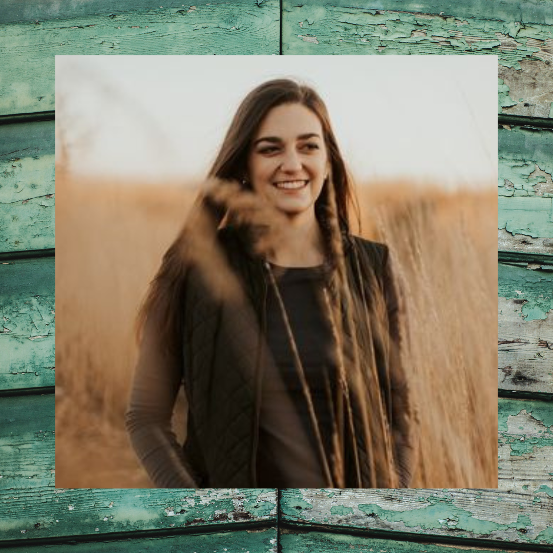 Photo of woman smiling standing in a field of tall grass