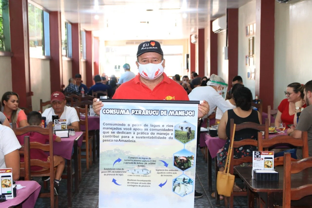 Raimundo Vasconcelos, proprietário da Peixaria Rayana exibindo banner da campanha.