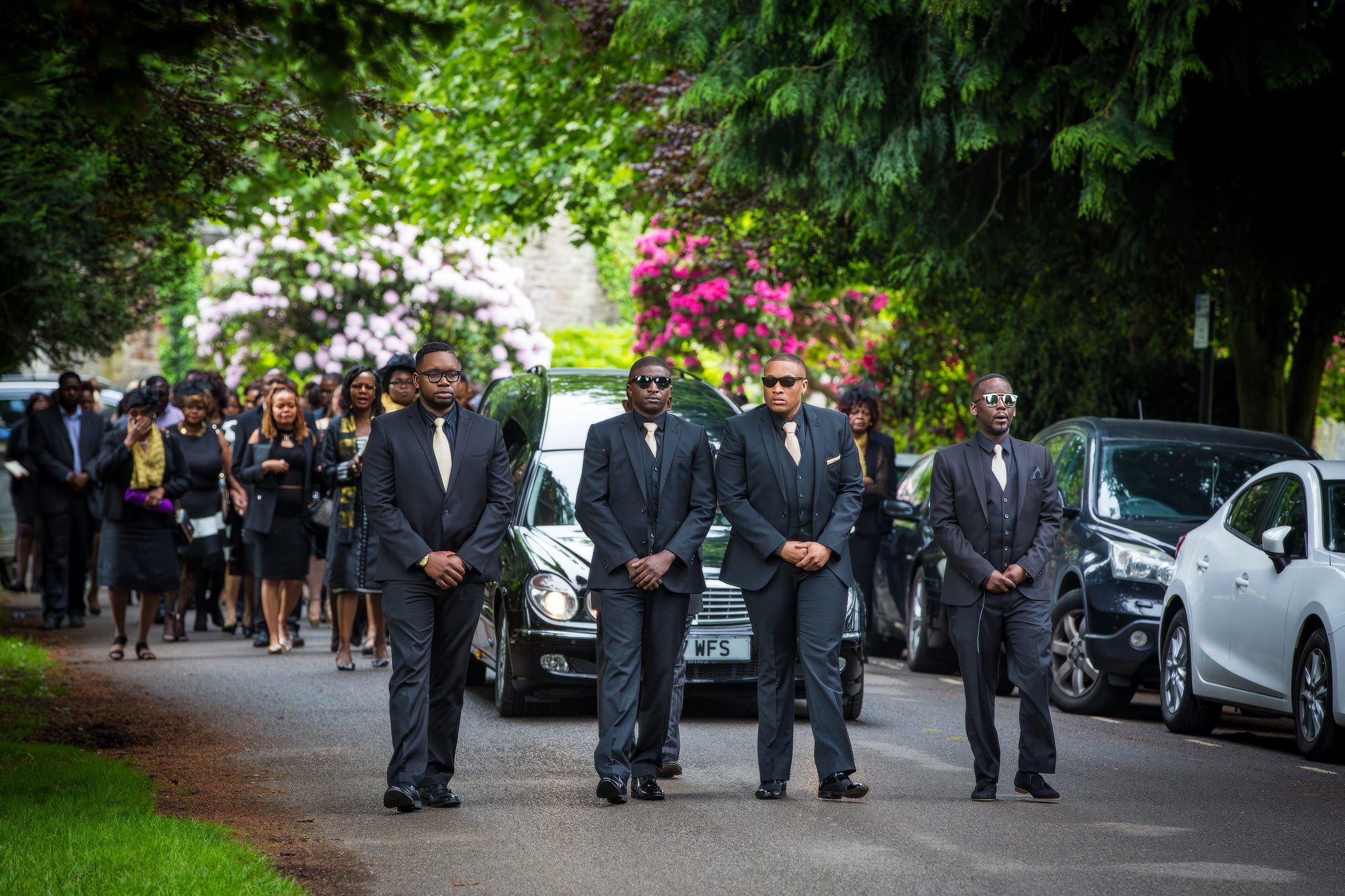 Bearers walking in front of the hearse at an African and Caribbean funeral procession, filmed and photographed by UK Funeral Video Services
