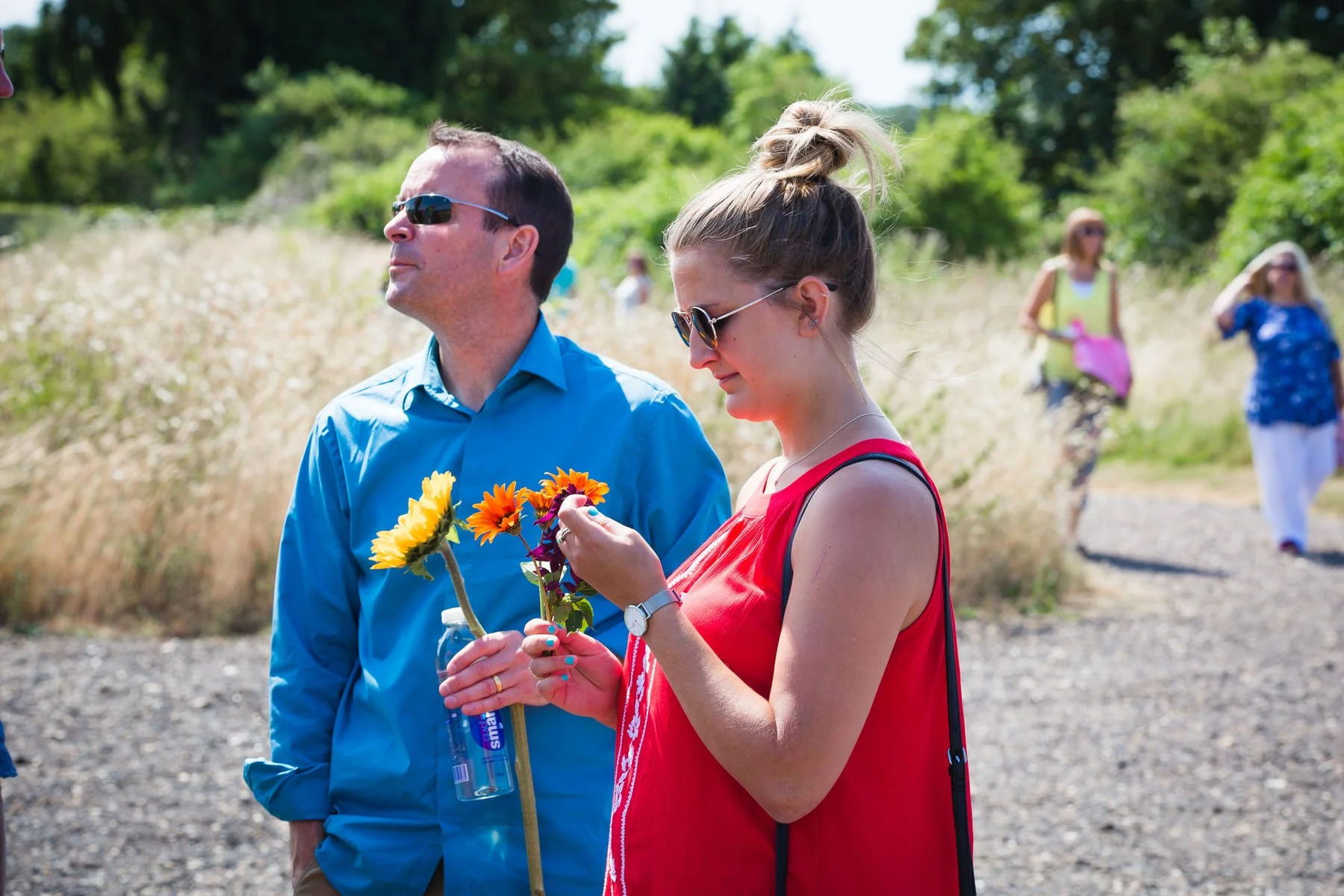 Guests arriving and greeting each other inside the glass pavilion at Clandon Wood natural burial ground in Surrey.